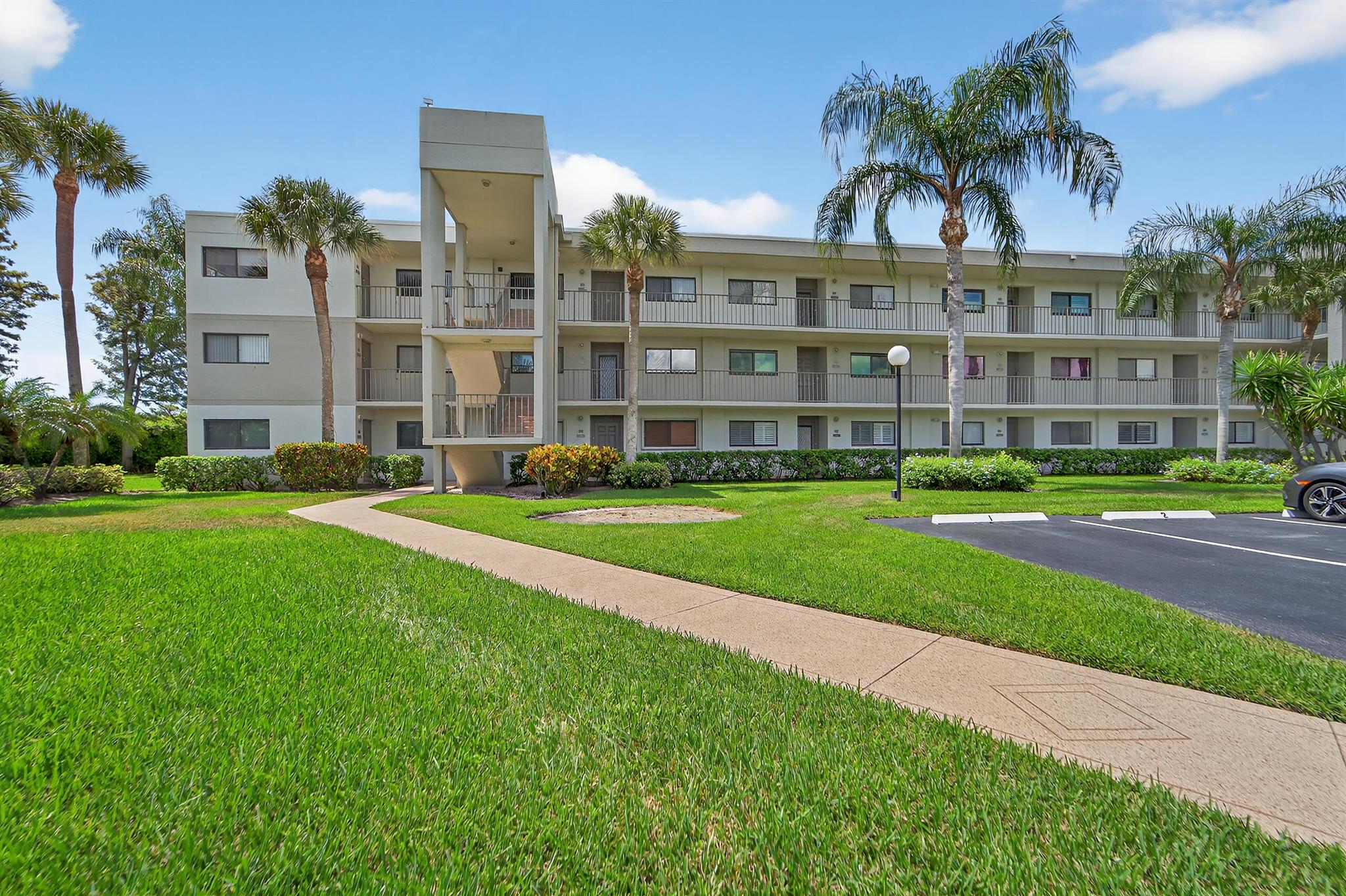 Cheerful, newly painted and spotless ground-floor unit condo with tranquil garden view. Spacious 1348 square foot layout features tile in every room.. Comfortable eat-in kitchen with granite counters and wood cabinets, newer appliances, and a pass-through to the dining area. Primary. bedroom offers a large walk-in closet plus an en-suite bath with updated vanity and toilet and separate and updated shower. Guest bath offers updated vanity and a tub-shower. 2 wall mounted smart TVs are included. The oversized laundry room holds full-sized and newer washer and dryer with room for additional storage. The enclosed screened patio with a garden view is is fully protected with newly installed hurricane accordion shutters, as are all of the other windows. Lakes of Delray is a 24 hour guard gated