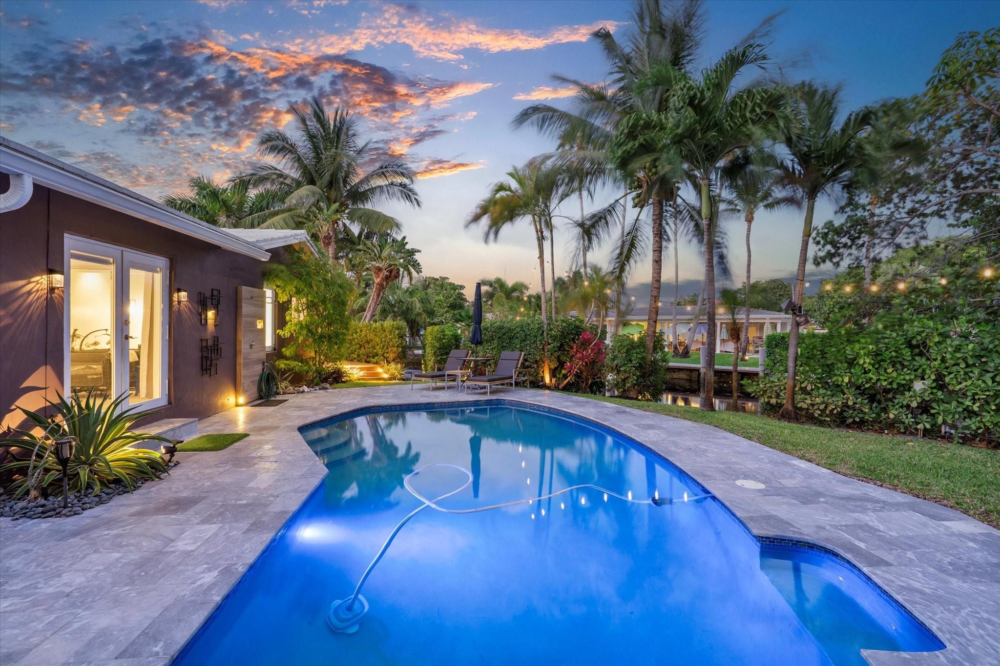 Modern loft-inspired home offering water views from every room, set on a private, elevated corner lot surrounded by palms, mango trees, & bamboo. The open layout showcases polished concrete & Italian tile flooring, creating a sleek mid-century aesthetic blended. The home includes 2 large primary suites with ensuite baths, along with a 3rd BD that features a versatile office alcove. A chef’s kitchen highlights quartz counters, induction cooktop, pro-grade hood, black stainless appliances, dual sinks, & custom soft-close cabinetry. Furniture available, excluding select heirlooms. Enjoy ocean-access canal frontage perfect for kayaking or fishing. Close to local dining, breweries, Fresh Market, Coral Ridge Mall, & the beach. Adtl features: 2car garage, impact windows/doors, & no HOA.