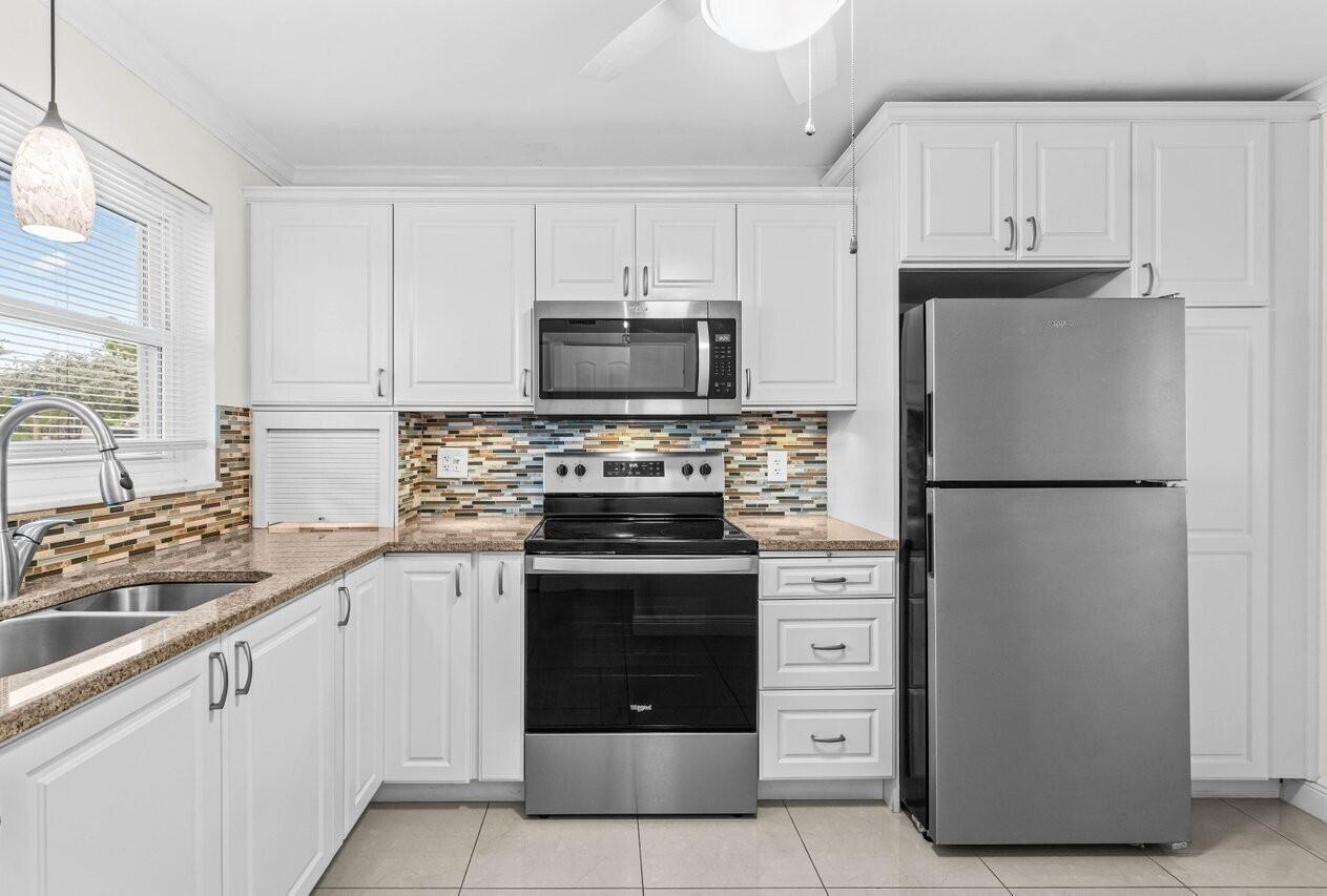 Bright and welcoming 2BR/2BA ground-floor end unit featuring elegant 20'' x 20'' high-gloss ceramic tile flooring throughout. The expansive living/dining area extends an impressive 31.5 feet, creating an open, airy feel. The updated kitchen boasts a 2020 Whirlpool stainless steel appliance suite, perfect for everyday cooking or entertaining. Located in the sought-after Seagate community, residents enjoy resort-style living with complimentary cable and WiFi, an updated clubhouse, two heated/cooled pools, bocce ball, yoga, putting green, shuffleboard, BBQ/picnic area, and a full calendar of social events. Ideally situated just minutes from shopping, dining, and pristine ocean beaches--this is Florida living at its finest!