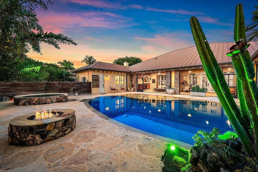 This incredible home offers 4 Bedrooms, 4.5 Baths, 8 Cars Garage, & Pool on 5.8 Acres. Welcome to ''Elephant Walk'', a private Palm City estate of rare distinction, on 5.8 pristine acres in the exclusive Stuart West equestrian community of Martin County. Designed in 2012 with CBS construction, this Southwestern-inspired residence blends architectural character with refined Florida luxury. Offering 3,667 sf under air and 6,277 sf total, the estate includes a 3BR, 3.5 BA Main Home plus a private 1BR/1BA Guest Cottage ideal for guests or extended stays. Rich African mahogany flooring, travertine tile, soaring 10-14 foot ceilings, impact glass, crown moldings, and Electrolux Icon appliances showcase exceptional craftsmanship throughout. Car collectors will appreciate the 6-8 car garages: Attached 3-car garage Plus 1,710-sq-ft detached 5-car garage/workshop. Detached garage has room for interior RV/Boat Parking. The owner's suite is a tranquil retreat featuring dual walk-in closets and a spa-style bath with jacuzzi tub and whole-body spray shower. A dedicated office, wine and coffee bar, and expansive great room enhance the interiors. Designed for entertaining, the 1,200-square-foot screened lanai features a custom horseshoe bar, gas fireplace, surround sound, and space for gatherings of 25 or more. Outdoors, enjoy a resort-style freeform pool with raised spa, firepit, and summer kitchen. The grounds unfold as a botanical sanctuary with winding stone paths, specialty palms, and a 3/4-acre lake. The Cape Club Golf Membership is available separately. Minutes from I-95, Turnpike, quaint downtown Stuart, golf, boating, dining, and beaches, Elephant Walk is more than a residence, it is a lifestyle retreat. Call Today for Your Private Showing!