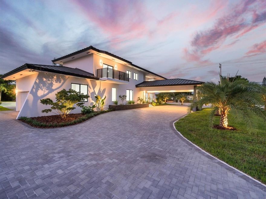 Nestled in the prestigious Miller Estates, this 7,000+ sq ft residence sits on over an acre in one of the most sought-after neighborhoods. A grand circular driveway, expansive carport, and pivot front door set the tone for a resort-like lifestyle. Inside, every detail shines—from a marble staircase, elevator, and water feature to a brand-new metal roof, impact windows, and designer LED lighting. Enjoy a massive kitchen, resort-style pool, basketball court, 2/1 guest house, and a bonus detached space ideal for a gym, yoga studio, or cigar lounge. Offering elegance, comfort, and privacy while just minutes from major highways, this estate truly has it all.