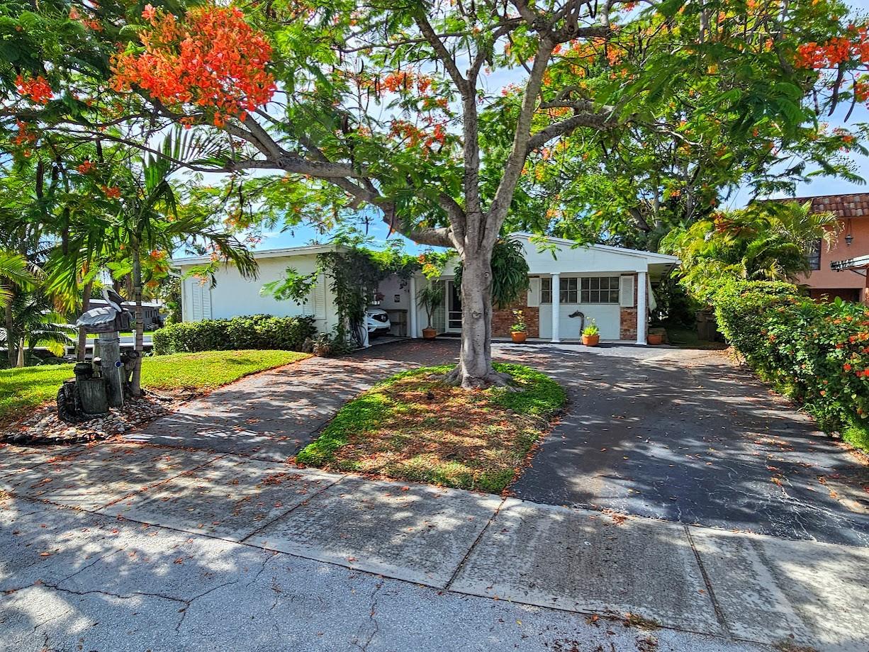 This Property is Truly a one of a kind waterfront home. 2bed 2bath with circular drive & car port with work shop, 114 ft of West facing waterfront on wide private canal with its own island, beautiful view of the entire canal and the Hillsboro River from its big overlooking deck. Canal behind property is owned and has its own folio #, One of the highest elevations in Deerfield NOT in a flood zone. Home is in the highly desirable waterfront neighborhood of twin oaks with only 45 waterfront Homes. Just off the Hillsboro Canal with only one high fixed bridge (Federal) and only minutes by boat to Lake Boca and Ocean. Nice quite neighborhood in a Great location 1 mile to beach, Pioneer Park and boat launch ramp are just around corner. Sale includes two properties.
