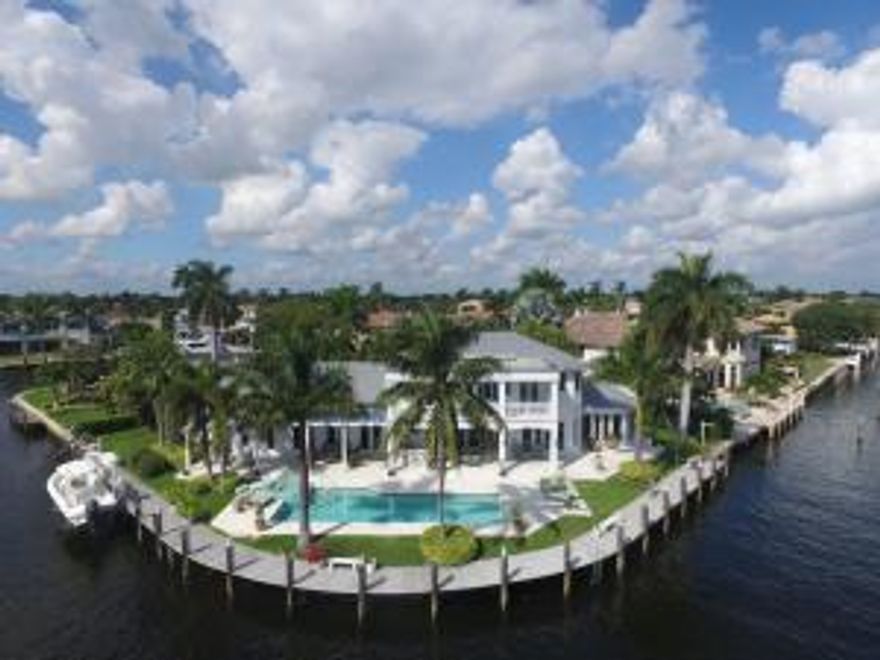 This fabulous British West Indies Home is situated on a remarkable 241+- Southeast Intracoastal Point Lot.  Features include a tranquil front patio, Open Floorplan with Cherry Wood floors thruout, First Floor Master Suite with an adjacent Office, Open Kitchen to large Family Room and Breakfast Area, 3 Ensuite Bedrooms upstairs, large balcony overlooking the Intracoastal and 2 additional down.  Large entertaining pool/ patio and dockage for a large yacht