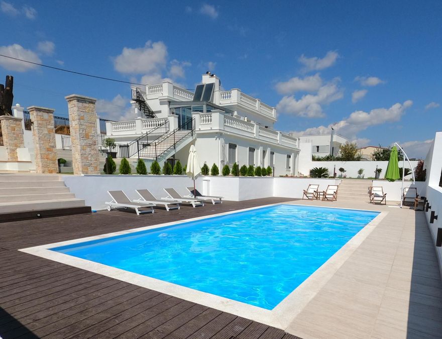 MODERN SEAVIEW VILLA | RAFINA | ATHENS RIVIERA (EAST) | GOLDEN VISA ELIGIBLE  Positioned above the Aegean Sea with uninterrupted east-facing views toward Evia.  Located approximately 25 minutes from Athens International Airport and close to Rafina's marina and ferry connections to the Cyclades, the property supports both private use and strong seasonal rental demand.   Priced at 950,000, the property qualifies under the 850,000 Golden Visa threshold for the Athens region and benefits from three consecutive years of proven summer rental income with strong 2026 bookings.    Rafina represents the eastern expansion of the Athens Riviera — an area undergoing infrastructure investment, port modernization, and integration into Greater Athens. Unlike the fully matured western coastal districts of Vougliameni & Glyfada, Rafina offers earlier positioning within the coastal pricing cycle.    This is a strategically positioned coastal asset combining lifestyle use, income performance, and exposure to the next phase of the Athens Riviera.    The Villa is designed across layered outdoor levels and features a private pool, multiple terraces, and an open roof deck framing panoramic sea view alongside clean, modern architecture and elevated positioning that enhances both privacy and usability,     The interior layout places sleeping quarters on the lower level for separation and comfort.   Request full brochure, rental income details, and viewing information.    Transaction will be completed using Local Greek Transaction Broker and in EUROS.