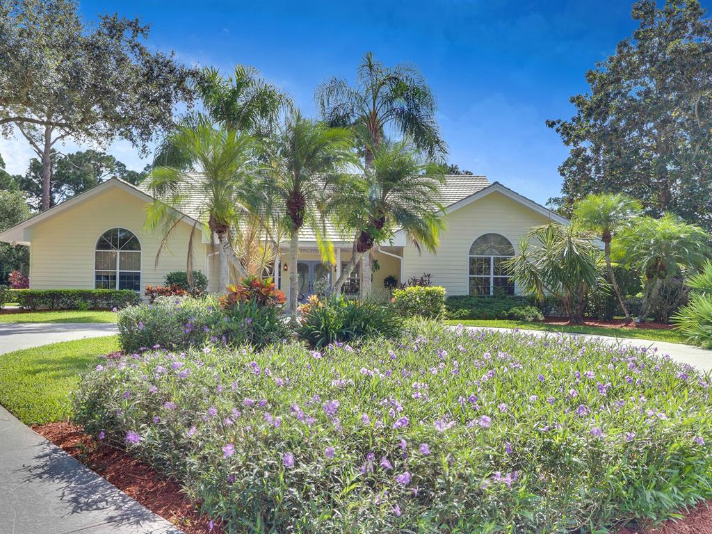Paradise at RESERVE PLANTATION! If you like Key West Style or playing Golf, you will fall in love with this spacious custom-built Key West home on a private cul-de-sac in PGA Village! This home with a large living area with a real burning fireplace graced by soaring ceilings and wall-to-wall french doors is a haven for gazing at nature views from multiple vantage points. The open floor plan encompasses three spacious bedrooms and a gourmet kitchen with upgraded appliances, wine cooler & counters that flow through to the large dining area. The large kitchen has a cook island housing a gas range and a convenient pass-thru to pool casual dining area. The hallway to the two guest bedrooms and guest bathroom, with a retro flair, has a pocket door for added privacy.