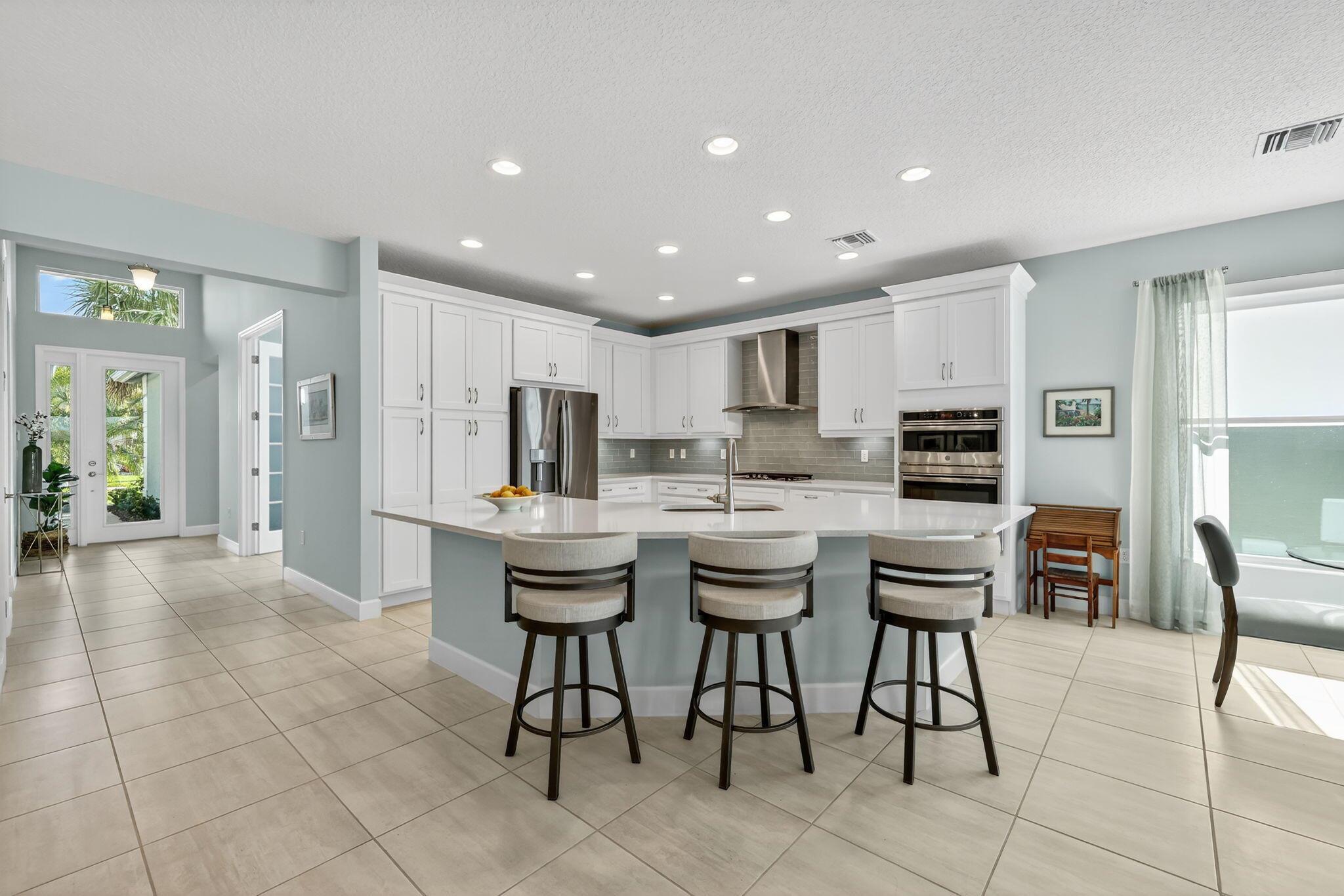 Welcome to your dream home in the sought-after 55+ community of Valencia Cay at Riverland! This beautifully designed Bimini Model sits on an oversized premium lakefront lot, offering breathtaking water views and the perfect blend of luxury, comfort, and lifestyle. Featuring 3 spacious bedrooms, 3 full bathrooms, a den/flex room, and over 2,358 sq. ft. of living space, this open-concept layout is ideal for entertaining and everyday living. The gourmet kitchen boasts quartz countertops, stainless steel appliances, a large island, and upgraded cabinetry, seamlessly flowing into the expansive great room and dining area, all overlooking the large, covered patio and sparkling lake with a south exposure.