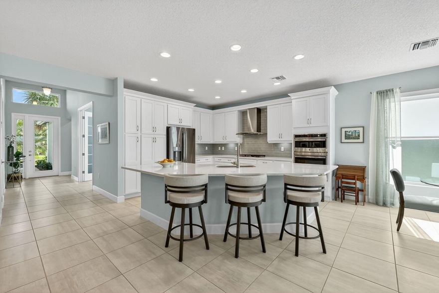 Welcome to your dream home in the sought-after 55+ community of Valencia Cay at Riverland! This beautifully designed Bimini Model sits on an oversized premium lakefront lot, offering breathtaking water views and the perfect blend of luxury, comfort, and lifestyle. Featuring 3 spacious bedrooms, 3 full bathrooms, a den/flex room, and over 2,358 sq. ft. of living space, this open-concept layout is ideal for entertaining and everyday living. The gourmet kitchen boasts quartz countertops, stainless steel appliances, a large island, and upgraded cabinetry, seamlessly flowing into the expansive great room and dining area, all overlooking the large, covered patio and sparkling lake with a south exposure.