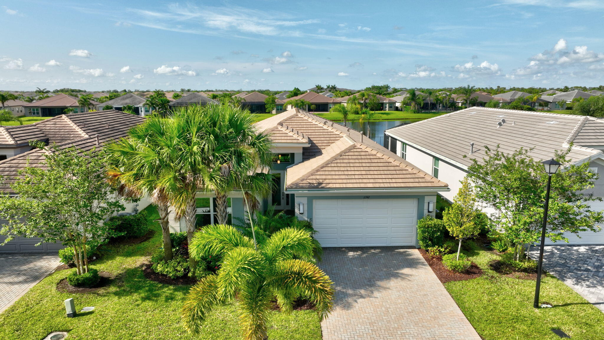 Welcome to your dream home in the sought-after 55+ community of Valencia Cay at Riverland! This beautifully designed Bimini Model sits on an oversized premium lakefront lot, offering breathtaking water views and the perfect blend of luxury, comfort, and lifestyle. Featuring 3 spacious bedrooms, 3 full bathrooms, a den/flex room, and over 2,358 sq. ft. of living space, this open-concept layout is ideal for entertaining and everyday living. The gourmet kitchen boasts quartz countertops, stainless steel appliances, a large island, and upgraded cabinetry, seamlessly flowing into the expansive great room and dining area, all overlooking the large, covered patio and sparkling lake with a south exposure.