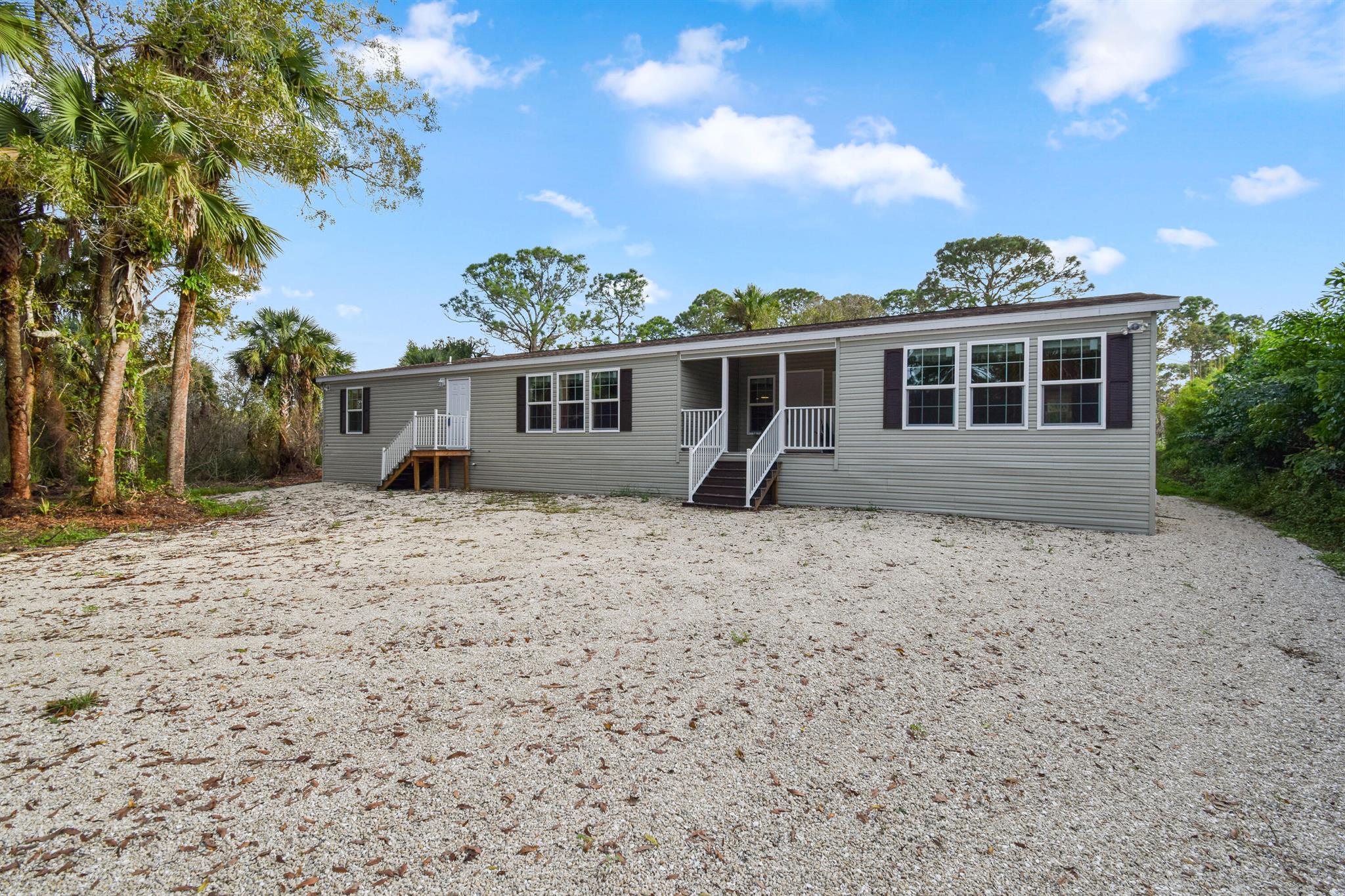 Welcome to this spacious 4-bedroom, 3.5-bathroom home in the serene community of Palm City Farms! Offering nearly 3,000 sq. ft. of thoughtfully designed living space, this home perfectly balances comfort, efficiency, and privacy. Built with high-impact windows and doors, upgraded insulation, and a dual-zone AC system. Inside, enjoy two strategically placed fireplaces, as well as a fully equipped kitchen with premium appliance package, top-of-the-line water filtration and a reverse osmosis system for superior water quality. Nestled on a private lot, this home is easily accessed via a quiet dirt road in a friendly neighborhood. Despite its peaceful setting, you're just minutes from shopping, top-rated schools, and have convenient access to I-95. Available for annual rental. FLS required.