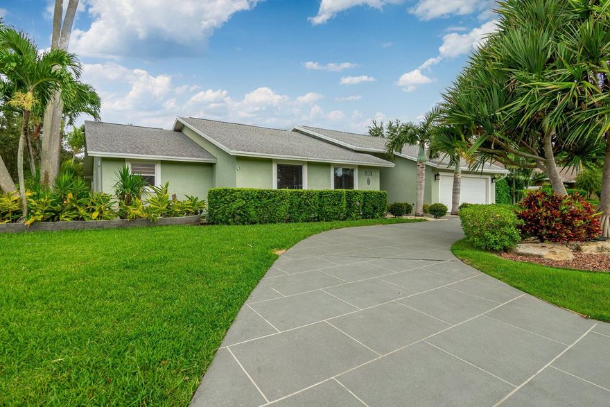 Conveniently set on a desirable corner lot, this unique Cypress Creek residence feels like home the minute you pull up. This open-concept home is warm and inviting, pronounced by its vaulted ceilings w/ wood beams and stone accent fireplace. A breakfast/dry bar ties in the fully remodeled kitchen featuring custom cabinetry upgrades, granite tops throughout and a large island at center.  Master bedroom includes walk-in closet. Both bathrooms have undergone complete renovations.  Outdoor living is at its best here, whether its out back under a lengthy lanai with outdoor kitchen or beside the pool in your tropical fenced in oasis.  And feel free to brush up on your short game on your own private putting green! Propane gas equipped home.  Guard gated community with a low HOA of  $117/month!