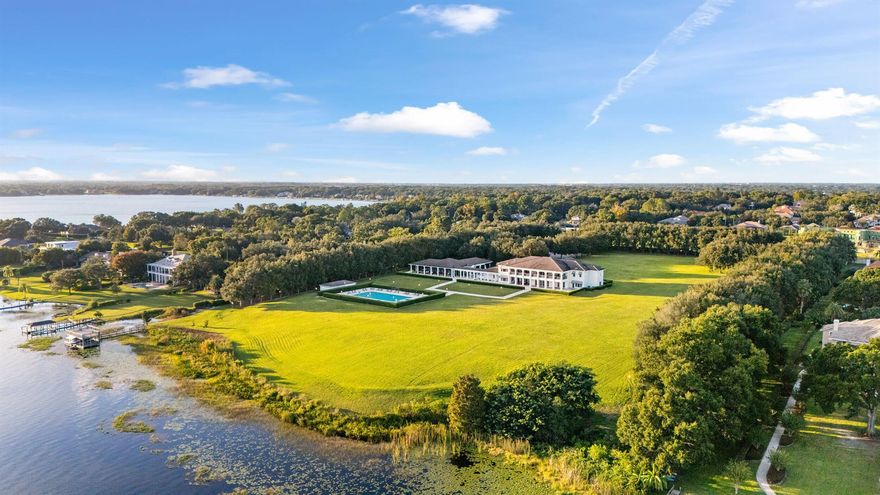 Discover this Perfectly positioned Georgian Estate situated on 12 acres (additional 6 acres available) of lakefront property with meticulously manicured grounds. This walled and gated compound includes approx 614 feet of pristine lake frontage and panoramic views on Lake Down of the Butler Chain of Lakes. The magnificent sprawling primary residence pairs classic Georgian architecture with modern amenities to achieve the ultimate lakeside retreat. Immediately you are greeted by the finest materials and finishes inside an elegant entryway which opens into a grand interior boasting a floating mahogany staircase, marble floors and paneled walls all framed by stunning Murano chandeliers. An art gallery leads into a spacious living room lined with mahogany walls and boasts expansive waterfront