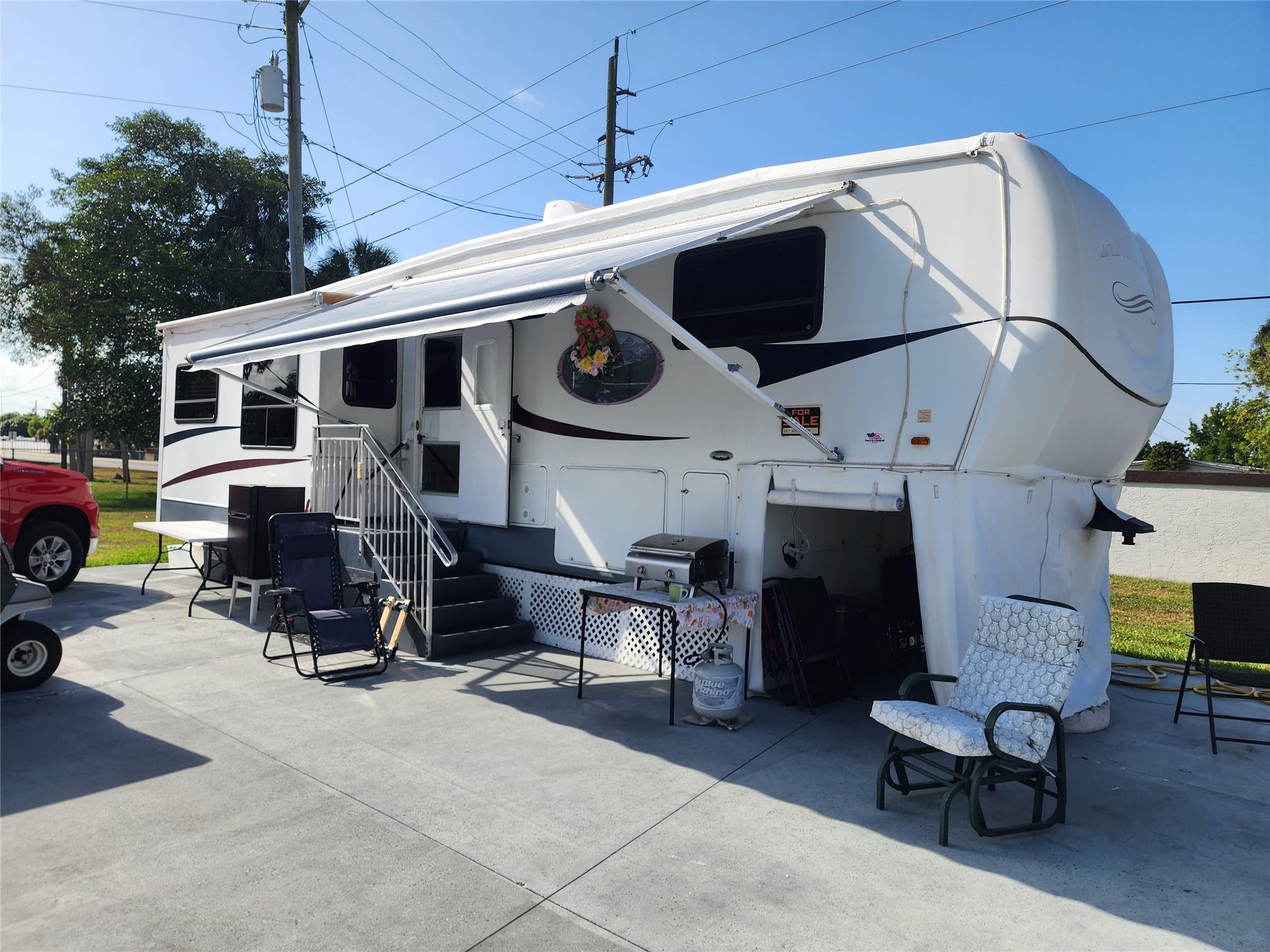 In Ancient Oaks with a 2005 Heartland Landmark fifth wheel with 3 slide outs and a storage shed. Located on a 1 way street, with hurricane tie downs, skirting, water/sewer hook ups. This well cared for home boasts leather lounger chairs, sofa sleeper couch, TV, dining room table & chairs , Front queen size bedroom with closet and a safe, plenty of storage & Splenda W/D combo in a closet. A full size shower. Many Cupboards, cabinets, drawers for storage. Includes fully equipped Kitchen. There are 2 AC units, 1 is new and the unit cools well. The roof was painted this year and has been sealed. There is a large basement storage. Even comes with a Cuisinart Gas Grill, His & Her bicycles, small outside refrigerator and is *Move in Ready*