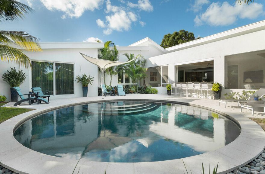 Unique home built on a large lot for the owner of Signature Builders Group.  All of the bells and whistles were added. Each bedroom has an ensuite bath.  The master bath has an exterior shower garden with a Hydro Air bath tub for two. Main living area has 20' vaulted cypress ceiling.  This ceiling extends outside the front entry door to the covered entry.  The loggia is extensive with separate living, dining and bar area which is completely screened.  The loggia also has hurricane rated power storm shutters that allow for the area to be secured at the push of a button for any weather events.  The bar has a power screen that allows service to the pool area. Smart home controls include speaker to 8 seperate zones. This home was designed for entertaining and must be seen to be appreciate.