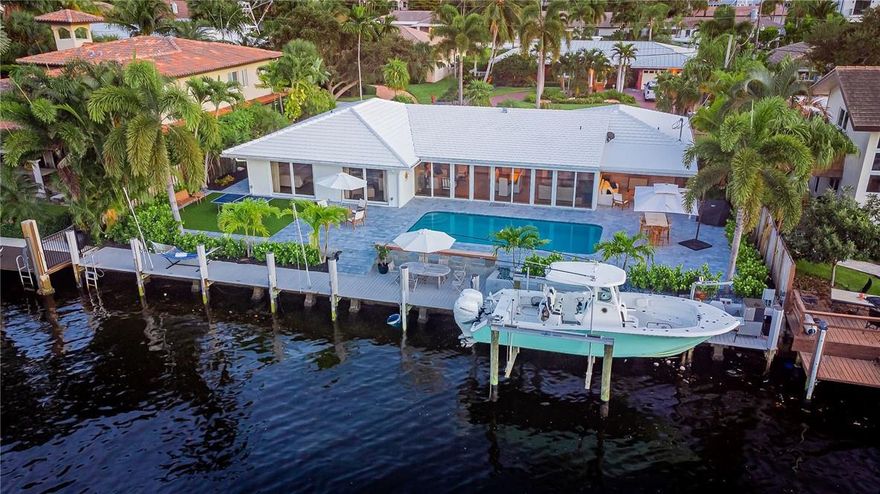 100' of magnificant deep water frontage in Coral Ridge Country Club. Truly a PRISTINE 4 bedroom, 2.5 bath, open custom kitchen with awesome quartz counter tops with huge island for eating and entertaining. A remodeled pool, pool deck, landscape and backyard lighting. Relax while in the pool on built-in seats. Beautiful 100' of dock including a 10,000 lb. boat lift with electric and water.  A South Florida fisherman's oasis!. Multiple outside seating areas, covered lounge area with TV and an Astro Turf play area. Canal is extra wide at 120 feet across and no fixed bridges. Prestigious Coral Ridge Country Club just one minute away!.