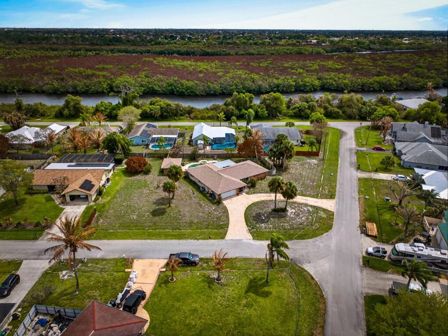 3BR/2BA home on an oversized 0.5-acre corner lot in Port St. Lucie! Featuring over 2,100 living sq ft, this home offers a split floor plan, spacious living areas, and abundant natural light. Enjoy a private pool with spa and NEW pool equipment, plus a fully fenced yard. Upgrades include a NEW roof (2025), NEW garage door, gutters, storm shutters, and newer stainless steel appliances. U-shaped driveway provides ample parking, and a large shed/workshop with electric adds extra storage or workspace. City water/sewer and well irrigation. Conveniently located near parks, shopping, dining, and just a short drive to Jensen Beach and Hutchinson Island!