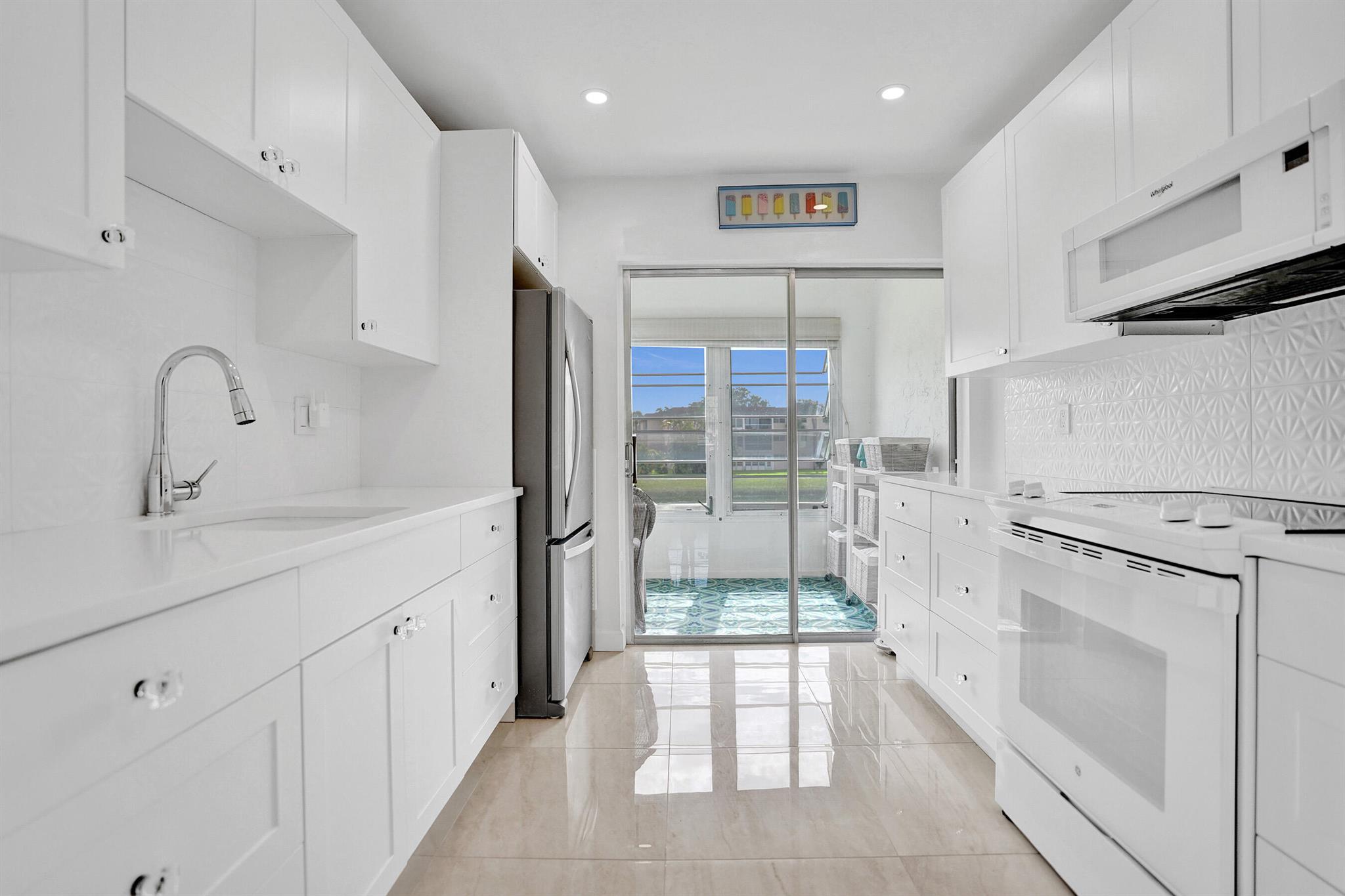 Fully renovated in 2023, this pristine 1-bedroom, 1.5-bath condo in Delray Beach's top-rated 55+ community offers stunning water views from the enclosed Florida room with double balconies. The modern galley kitchen features quartz countertops, stacked drawers, a designer backsplash, garbage disposal, and top-of-the-line stainless steel appliancesa"including a stove that's barely been used. Porcelain flooring flows throughout, complemented by custom LED lighting, crystal knobs, and high-end doors. Both bathrooms are completely updated with frameless glass doors and elegant finishes. The spacious bedroom includes a custom walk-in closet. Enjoy peace of mind with a 2023 roof, A/C (2018), water heater (2019), and upgraded outlets and switches. HOA covers internet, cable, water, lawn care,