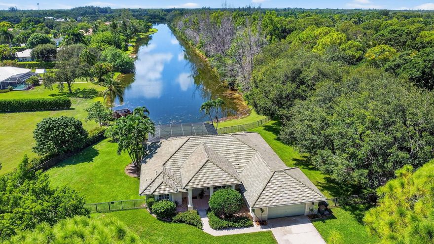 At the end of a quiet cul-de-sac, tucked away, this beautifully appointed 3 bed, 2.5 bath home sits on a sprawling rare 1.17 acre lot, offering unmatched privacy & stunning long lake views. An impressive 342-foot private driveway leads to the property, providing not only ample parking but also a grand, exclusive entrance.Step inside to discover an open, light-filled floor plan w/ soaring ceilings & panoramic water views. The thoughtful split bedroom layout creates the perfect environment for both daily living  & entertaining, w/multiple sliding doors that open to a spacious covered patio & screened in pool, ideal for enjoying the outdoors year-round.The chef-inspired kitchen is equipped w/ high-end JennAir appliances, including an induction range & plenty of cabinet space.