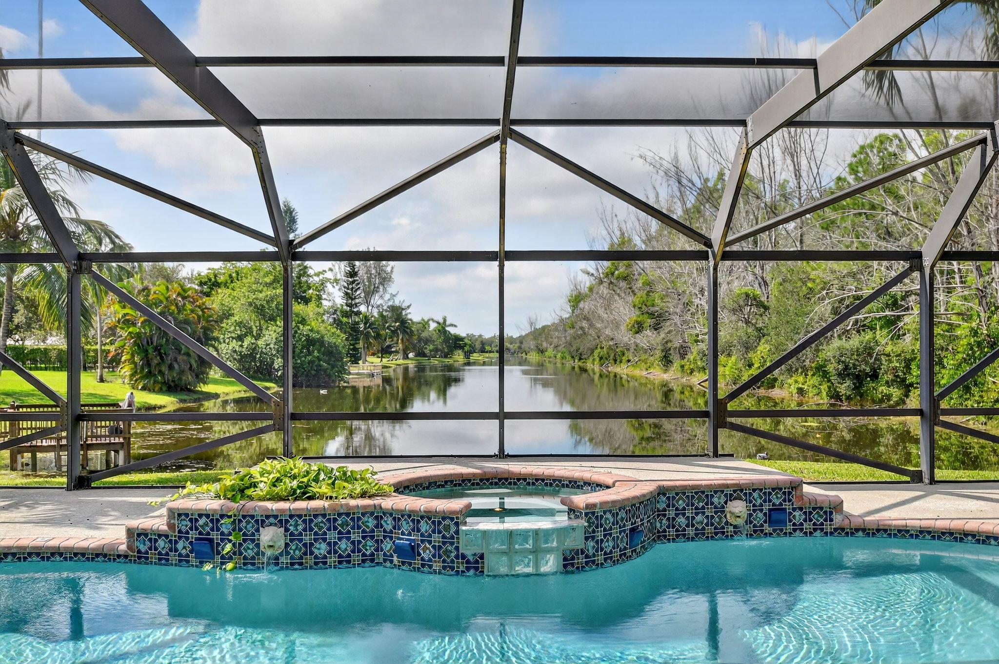 Tucked away at the end of a quiet cul-de-sac, this beautifully appointed 3 bed, 2.5 bath home sits on a sprawling 1.17 acre lot, offering unmatched privacy & stunning long lake views. An impressive 342-foot private driveway leads to the property, providing not only ample parking but also a grand, exclusive entrance.Step inside to discover an open, light-filled floor plan w/ soaring ceilings & panoramic water views. The thoughtful split bedroom layout creates the perfect environment for both daily living  & entertaining, w/multiple sliding doors that open to a spacious covered patio & screened in pool, ideal for enjoying the outdoors year-round.The chef-inspired kitchen is equipped w/ high-end JennAir appliances, including an induction range & plenty of cabinet space.