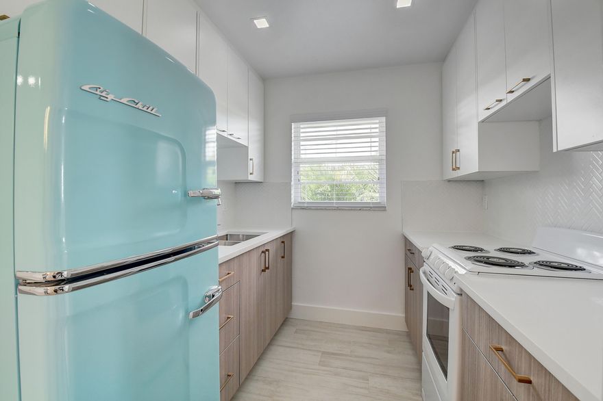 AN ABSOLUTE STUNNER APARTMENT WITH MANY UPGRADES.  CUSTOM KITCHEN WITH QUARTZ COUNTERTOP AND STYLISH TILE BACK SPLASH.  A SUPER COOL 'BIG CHILL' TURQUOISE RETRO REFRIGERATOR.  MARBLE FLOORS IN THE BATHROOM WITH A FLOATING VANITY.  WALK IN CLOSET.  ALL IMPACT WINDOWS WITH CENTRAL A/C, CUSTOM FIT BLINDS AND AN ELECTROLUX WASHER & DRYER INSIDE THE APARTMENT.  PRIVATE OFF STREET PARKING NEXT TO UNIT.  PROPERTY SITS IN THE DOWNTOWN, WALKING DISTANCE TO LOTS OF RESTAURANTS AND SHOPPING.  GREAT PROXIMITY TO THE BEACH AND QUICK COMMUTE TO WEST PALM BEACH.