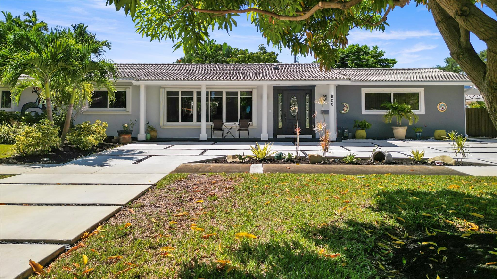 Beautifully updated Hollywood home on a corner lot! This bright, open-concept residence offers impact windows, a modern kitchen with breakfast bar, spacious living areas, stylish finishes, and an oversized garage with storage. Includes a versatile spare room that can serve as an in-law suite, office, or guest space. Lush landscaping, mature trees, and room for a pool. Easy to insure and move-in ready. Special Offer: Use our preferred lender and receive a 1% giveback toward closing costs or a rate buy down!