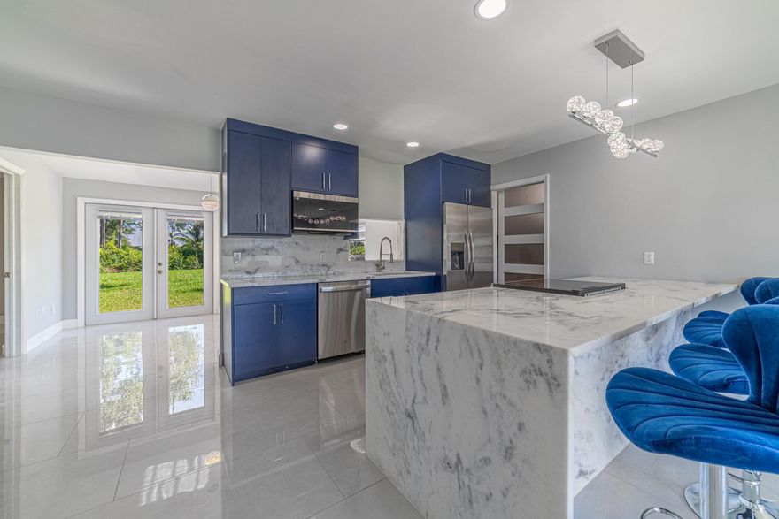 A MUST SEE! Finishes you would expect in a luxury home for less than half the price. FOUR bedrooms and two bathrooms in this well thought out, spacious 1,600+ sf home. One of the first questions buyers ask — how old is the roof? It is BRAND NEW and recently completed!New 12" x 24" tile floors with a brilliant sheen throughout. Smooth level 5 ceilings with upgraded dimmable recessed lighting. Both showers are surrounded by oversized tile. The primary bathroom features a floating European vanity and an impressive 8-foot-long oversized shower with a 10" x 10" waterfall spa dispenser and glass enclosure to the ceiling. The kitchen offers all new appliances, stunning 48" navy-blue cabinets with chrome hardware, and an oversized granite waterfall peninsula with built-in oven and stove.  Granite countertops, an extra-deep modern sink, and a dedicated coffee bar — perfect for starting your day.Also included is a large-capacity washer and dryer in a separate laundry room with a sliding barn door for privacy. Just behind the kitchen is another spacious area ideal for a formal dining room or play space. At the front of the kitchen is an open-concept family room with a large window providing abundant natural light.Much of the backyard has been freshly sodded with additional hedges planted. The entire yard is fenced and/or hedged for complete privacy — perfect for entertaining, relaxing, or weekend gatherings. A swinging six-foot wooden fence to the right of the home features an 8-foot opening, ideal for securely storing a boat, jet skis, or RV.The front exterior is stylishly updated with a new impact door and accent stonework, creating a modern, sleek look. The surrounding area offers A-rated schools, along with dozens of brand-new restaurants and cafes in the newly completed plaza just minutes away. Tradition is also nearby and offers a wide variety of dining, shopping, and entertainment.Come see this fully renovated turnkey home — nothing needs to be done. Just move in and start enjoying your new lifestyle!Buyer to verify all measurements, features and property details. Listing agent and brokerage assume no responsibility for accuracy or omissions.