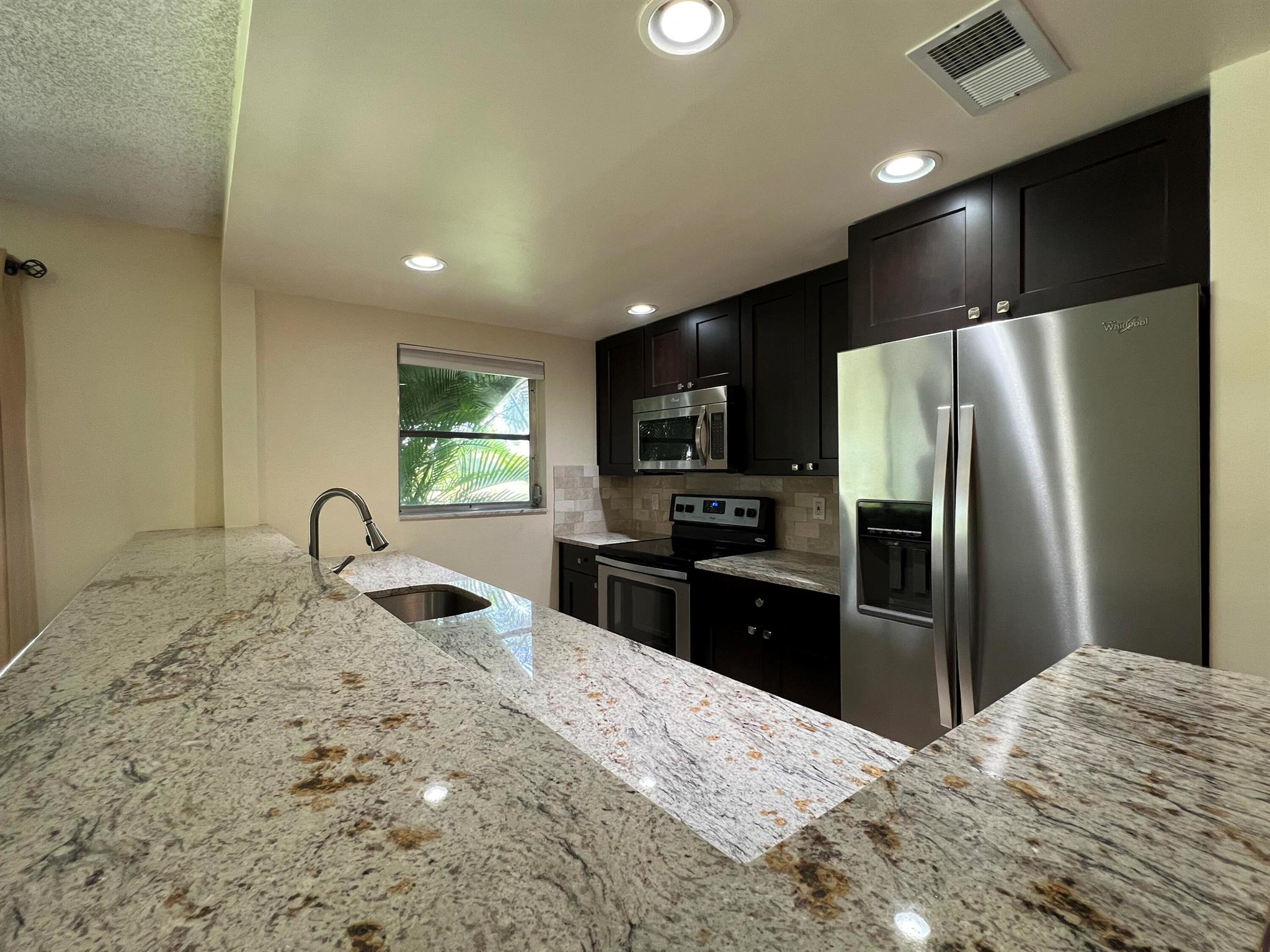 Renovated 1 bed / 2 full bath Villa located within the in the highly desirable Section 3 at High Point a 55+ Community in Delray Beach. This unit is beautifully upgraded with kitchen granite countertops, backsplash, seated bar for casual dining, stainless steel appliances, premium flooring throughout, and a custom mirror in the dining area. The bedroom has a walk-in closet and the master bathroom feature granite countertops, neutral wall color, tile flooring, and a combo tub/shower. Right off the bedroom, you will find a cozy glass-screened Florida room with views over the community, perfect for extra storage space, additional seating, or dining. The second bathroom is just as functional and has a walk-in shower, granite countertop, and modern framed mirror.