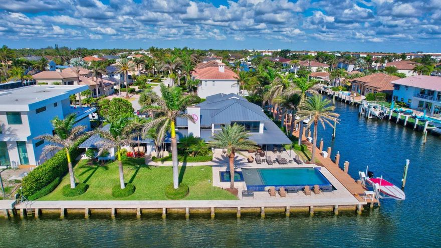 A magical modern contemporary Intracoastal point lot estate with 310 feet of deepwater frontage, including 185 feet on a side canal, this furnished residence is a yachtsman's dream, accommodating vessels up to 150 feet. The stunning resort-style infinity pool and spa offer breathtaking views, while the meticulously crafted aluminum roof and high-voltage landscape lighting enhance the modern appeal. Inside, the fully renovated interiors feature a striking floating staircase, 9-foot solid core doors, and a master bath that exudes timeless charm. The versatile garage is newly refinished and air-conditioned, ideal for various uses. and fresh paint throughout. The large covered outdoor area, complete with a chef's summer kitchen, is perfect for entertaining. Top-of-the-line appliances from Sub-Zero, GE Monogram, and Miele are in impeccable condition, complemented by a 30 kW Generac generator and a complete internet upgrade for uninterrupted living. With Lutron lighting and electric blinds in all bedrooms, this home is not just a residence; it's a lifestyle of ultimate waterfront living.