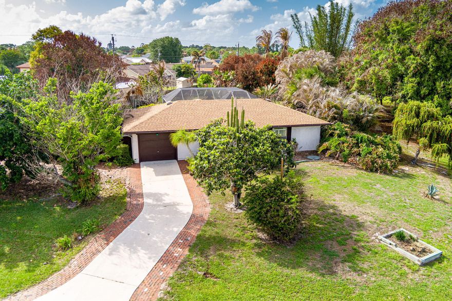 Discover this very rare 2BR/2BA ranch-style home on an oversized, half-acre corner lot in Port St. Lucie! The home features a beautiful granite kitchen with wood cabinets, stainless steel appliances, and a breakfast bar. Spacious open layout with vaulted ceiling, living room, dining, and a large family room/office with a built-in.  Beautiful low-maintenance tile flooring throughout! Great outdoor space with a screened pool, raised spa w/ waterfall, porch, and patio, perfect for entertaining! The pool has a caretaker system for easy cleaning. Very rare and hard-to-find half-acre lot, fully fenced, with a s double gate, workshop, and a large backyard. Plenty of room for a boat or an RV. Beautifully landscaped with fruit trees & palms. ROOF replaced in 2023! Washer & dryer included.  City water/sewer. No HOA fees! Conveniently located near parks, shopping, dining, I-95, and the Florida Turnpike.