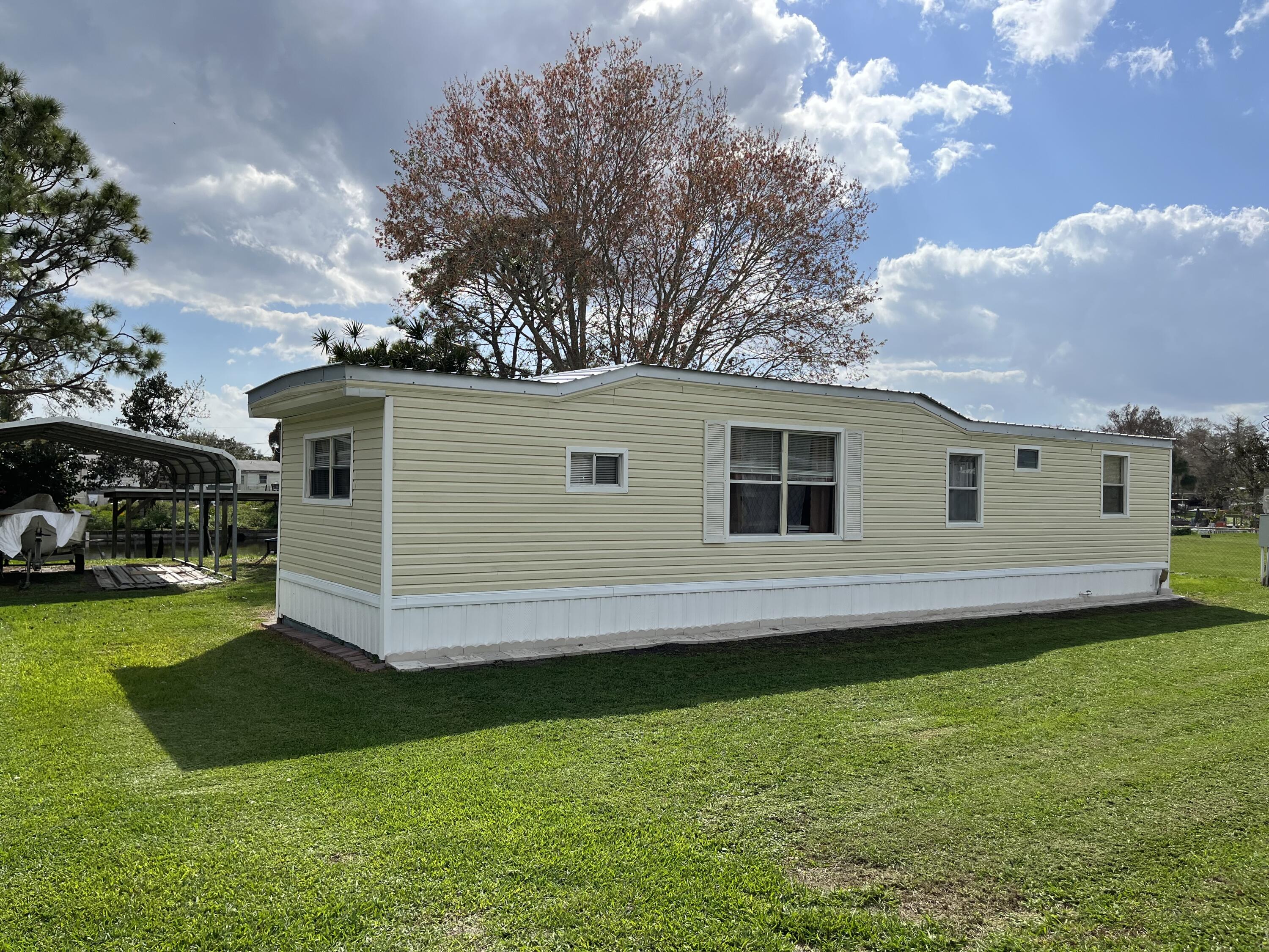 LOCATION, LOCATION, LOCATION! !!!!!Calling all fishers to see this Treasure Island - Lake Okeechobee Access 2/1 mobile home with a new metal roof Located on a beautiful waterfront lot with its own 40ft covered boat dock, and lift. including a screened 10x10 covered patio that oversees the canal this property also has a newer 12x16 shed with power and an18x20 carport. Nice size fully fenced yard for you to bring your boat and RV.