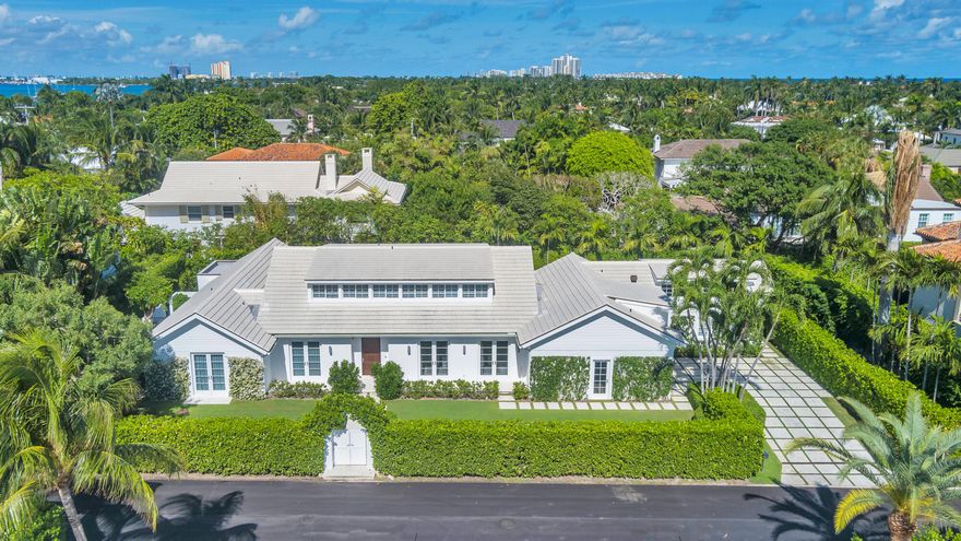 Located on the highly desired North End of Palm Beach, this two-story residence offers a contemporary design with luxurious finishes throughout. The state-of-the-art kitchen is a highlight of this home, perfect for those who appreciate modern architecture. The property boasts a spacious pool and spa, along with a charming guest cabana. With a total of 8 bedrooms and 8.5 bathrooms, this home offers ample space for comfort and relaxation. Recent enhancements include new lighting fixtures, outdoor loggia screens, fresh landscaping, surveillance cameras, and smart home devices. Colonial Lane offers a tranquil beach cabana area with shaded palm trees, dining tables, an outdoor shower, and comfortable lounge furniture.