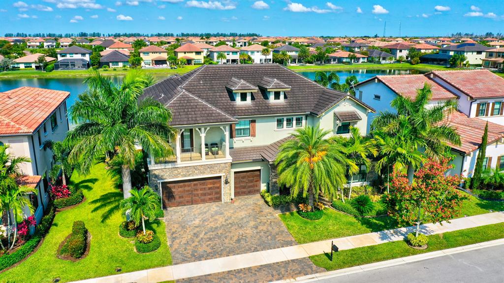 Beautifully situated home in the exclusive Watercrest community. Walking into this home you are met with a magnificently designed layout. The main floor consists of a grand foyer, dual living rooms, dining room, office, family room, and a custom designed Chef's kitchen. The 1st floor also boasts a guest suite with its own private bathroom. Located on the 2nd floor is the master suite where no expense was spared. 3 more bedrooms and 2 more bathrooms are located on the 2nd floor. To complete the upstairs there is an oversized game room/movie room great for entertaining. Once you are done inside the S. FL fun continues outside with a covered lanai leading to the pool overlooking the beautiful lake. When entertaining, family living, and community are priorities then this is the home for you!!!