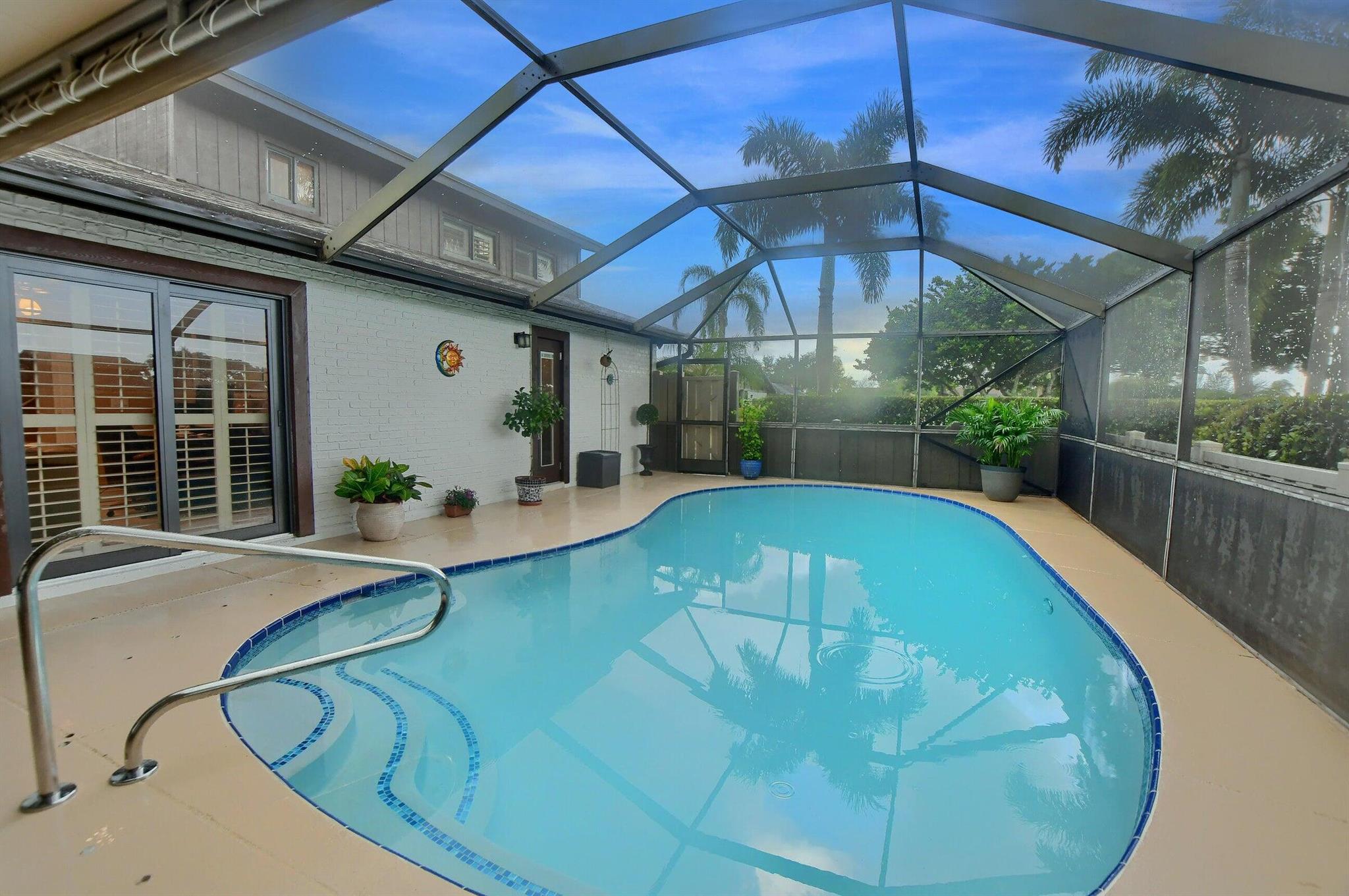 OPEN HOUSE SUNDAY , AUGUST 17 12-2PM. Move-In Ready Townhouse in Boca Gardens with Scenic Lake Views!RARE BEST OF THE BEST POOL HOME!Welcome to this charming 3-bedroom, 3-bathroom townhouse with pool in the highly desirable Boca Gardens community and one of the most desired ''Azalea'' models. Featuring 1,325 sq. ft. of interior living space plus an additional 800 sq. ft. of private, screened-in outdoor living area, this home offers a well-laid-out floor plan perfect for everyday living and entertaining.The open concept showcases beautiful, easy-to-maintain tile flooring throughout the main living areas downstairs and laminate in the 3 bedrooms with a thoughtfully designed kitchen and a comfortable flow throughout.Each bedroom features its own en-suite bathroom for added privacy