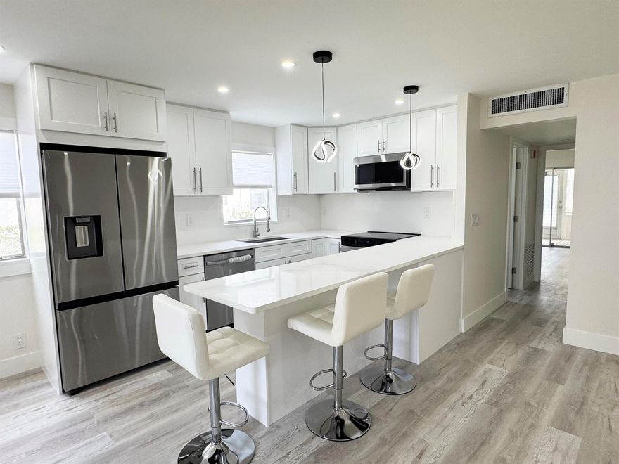 Stunning fully reimagined 2/2 condo in the highly desired Brittany section of Kings Point! This light-filled home features a-new modern kitchen with white shaker cabinets, soft-close drawers, stainless steel appliances, quartz countertops, and a beautiful peninsula with bar seating. Enjoy luxury vinyl flooring throughout, LED lighting, new interior doors, fresh paint, and a completely reimagined bathroom with frameless glass shower, modern tile, and updated fixtures.This move-in-ready home offers peace of mind with new lighting, modern finishes, and a bright open layout. Located steps away from the main Kings Point clubhouse, pools, theaters, golf, restaurants, courtesy buses, and all amenities.