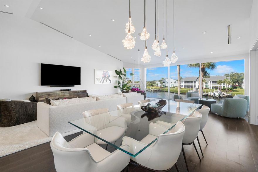 Stunning, fully renovated Harbor Home on a prime point lot in Jupiter's prestigious gated Admirals Cove.  Steps from the main clubhouse to enjoy, marina cafe, spa, pool, tennis, pickleball, golf, and more.. This home features 3 bedrooms, 3.5 baths, soaring ceilings, floor-to-ceiling La Finestra windows with breathtaking water views. The chef's kitchen boasts Taj Mahal quartzite countertops, Thermador and Fisher & Paykel appliances, and a wine cooler. The luxurious primary suite offers a Japanese soaking tub, dual sinks, oversized walk-in closet with stunning views. Additional highlights include high-end hardwood flooring, elevator, impact windows, electric shades, 3-zone AC, and private boat slip w/ lift. Move-in ready to enjoy the ultimate lifestyle in one of Jupiter's top locations.