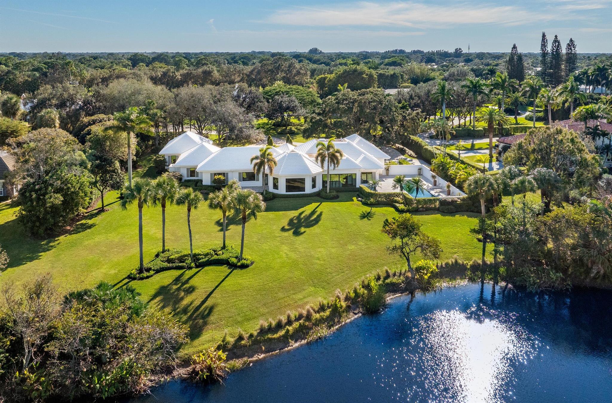 Presenting a masterpiece of modern luxury and timeless tranquility in one of the most sought-after locations in the Village of Golf. Nestled on 1.99 acres of meticulously manicured grounds, this stunning 5 bedroom, 4.1 bath estate unveils panoramic vistas of a serene pond and the verdant fairways of a prestigious golf course creating a sanctuary of elegance and sophistication. The main residence, a sprawling 3-bedroom, 3.1-bathroom home, is designed for both comfort and elegance. Thoughtfully appointed with high-end finishes and designer light fixtures throughout, it boasts a spacious layout, ideal for entertaining or simply unwinding in style. Adding to the allure is a charming 2-bedroom, 1-bathroom guest house, perfect for accommodating visitors or creating a private workspace.