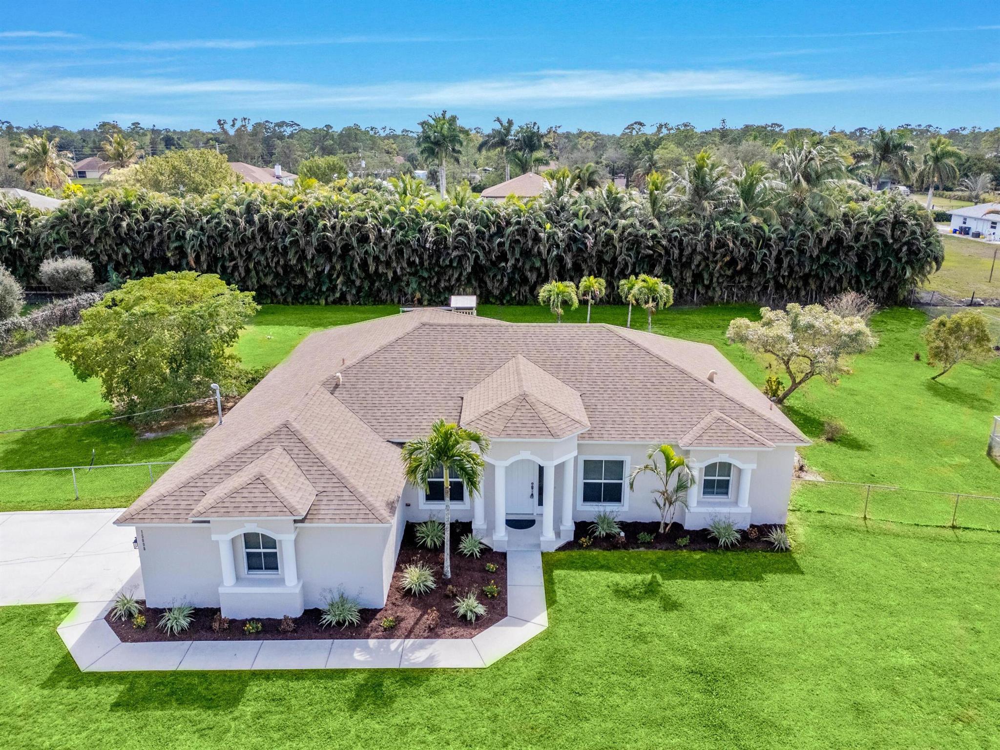 This stunning 4-bedroom, 3-bath home with a den sits on 1.15 fully fenced acres in the heart of Loxahatchee! Designed for both comfort and style, the spacious open floor plan is filled with natural light and features large bedrooms and a screened-in porch--perfect for relaxing or entertaining. Freshly painted inside and out, this move-in-ready home is your chance to create your own private oasis. With NO HOA, bring your pets, RV, or boat and enjoy true freedom! Ideally located just off a paved road, you're minutes from A-rated schools, shopping, and dining. Experience the best of both worlds--convenience and tranquility--right at home! Some photos have been virtually staged.