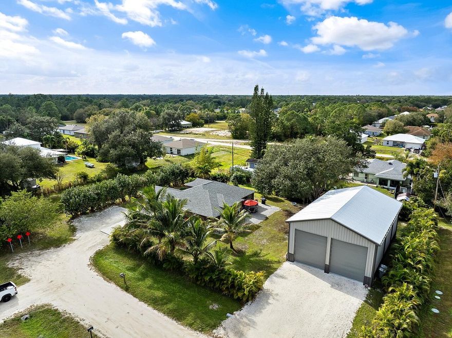 Built for serious RV, boat, and equipment owners, this rare .52-acre property in Vero Lake Estates delivers true freedom and infrastructure. Located in unincorporated Indian River County with NO HOA, the property is anchored by a $250,000+ commercial-grade steel 1925 Sq Ft workshop built by MBMI Buildings, engineered for durability, access, and long-term performance.The 55' x 35' x 25' over-engineered steel building features two 16-ft high doors, allowing effortless drive-in storage for large RVs, boats, trailers, and commercial vehicles. Designed for real use, the building includes 100-amp and 50-amp RV hookups, water access at both the front and rear, gutters with four downspouts, whole-building generator conduit, and CAT-5 wiring ideal for storage, maintenance, hobbies, or business