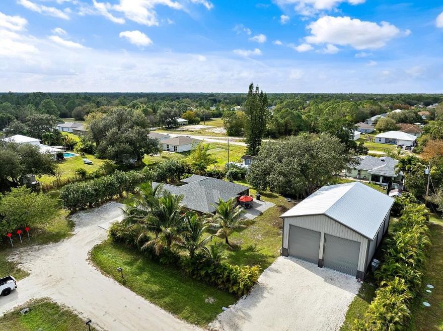 Built for serious RV, boat, and equipment owners, this rare .52-acre property in Vero Lake Estates delivers true freedom and infrastructure. Located in unincorporated Indian River County with NO HOA, the property is anchored by a $250,000+ commercial-grade steel 1925 Sq Ft workshop built by MBMI Buildings, engineered for durability, access, and long-term performance.

The 55' x 35' x 25' over-engineered steel building features two 16-ft high doors, allowing effortless drive-in storage for large RVs, boats, trailers, and commercial vehicles. Designed for real use, the building includes 100-amp and 50-amp RV hookups, water access at both the front and rear, gutters with four downspouts, whole-building generator conduit, and CAT-5 wiring ideal for storage, maintenance, hobbies, or business operation without restrictions.

The renovated 1,762 sq ft CBS home built by Groza Homes complements the workshop with a comfortable split floor plan, 3 bedrooms, 2 bathrooms, and a 2-car garage. Updates include a redesigned kitchen with granite countertops and newer appliances, tile flooring throughout, 2020 roof with peel-and-stick waterproofing, HVAC 2021, hot water heater 2022, upgraded electrical, new well pump, whole-house dehumidifier, whole-house surge protection, and advanced water filtration.

The primary bathroom has been fully renovated, offering a spa-like retreat with a coastal-modern feel. It features a custom walk-in shower wrapped in striking multi-tone plank tile, a pebble-stone shower floor, brushed nickel fixtures, rainfall-style showerhead, and a double-sink vanity with quartz-style countertops and updated lighting.

Outdoors, enjoy 10+ mature fruit trees, including dragon fruit, mango, and avocado, along with an optional security system.

A truly rare opportunity to own proper RV and boat infrastructure paired with a move-in-ready home, offering space, power, and freedom in one of Vero's most sought after no-HOA areas.