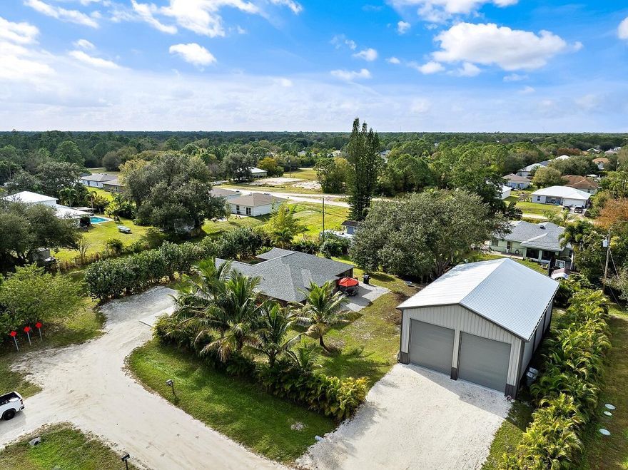 Built for serious RV, boat, and equipment owners, this rare .52-acre property in Vero Lake Estates delivers true freedom and infrastructure. Located in unincorporated Indian River County with NO HOA, the property is anchored by a $250,000+ commercial-grade steel 1925 Sq Ft workshop built by MBMI Buildings, engineered for durability, access, and long-term performance.The 55' x 35' x 25' over-engineered steel building features two 16-ft high doors, allowing effortless drive-in storage for large RVs, boats, trailers, and commercial vehicles. Designed for real use, the building includes 100-amp and 50-amp RV hookups, water access at both the front and rear, gutters with four downspouts, whole-building generator conduit, and CAT-5 wiring ideal for storage, maintenance, hobbies, or business