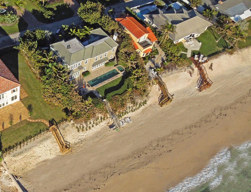 This beautiful original 1924 Mizner-style oceanfront beach home has a long history of being photographed and painted, and during it’s almost 90-year history has been occupied by only 2-owners. Recently painted and renovated, this home has retained the charm, look, design and feel of the original property, and offers the uniquely discriminating buyer an opportunity to own a piece of history while providing the very best in oceanfront, single-family living.  Located on quiet, historic Anna Street, this 3,000SF two-story, 3-BR/3BA home retains the look and feel of the original home that attracted artists and photographers trying to capture its beauty. From the marble & carpeted floors and crown molded ceilings, to the granite counter-tops in the center Island modern kitchen with its custom cabinetry, the gorgeous views from the dining room to the backyard, the open patio with lap pool and spa, plus direct beach and ocean access  this historic home has it all.
There are many special touches like the coffered, tongue-and-groove ceiling in the master bedroom, and Dade County hardwood floors that add charming touches of class throughout the home. The master bath, with its huge glass shower and separate tub has a large, well-lit and mirrored vanity area for her.
Every room takes advantage of the incredible natural light that flows throughout this 2-story home. Other amenities include hurricane impact windows, direct beach and water access, a driveway and 2-car garage parking, and fabulous biking & jogging areas close-by. Add to this the wonderful dining and world-class shopping just minutes away and you have the perfect opportunity to own a piece of old-Florida history while living your dream in the charming community of Ocean Ridge.