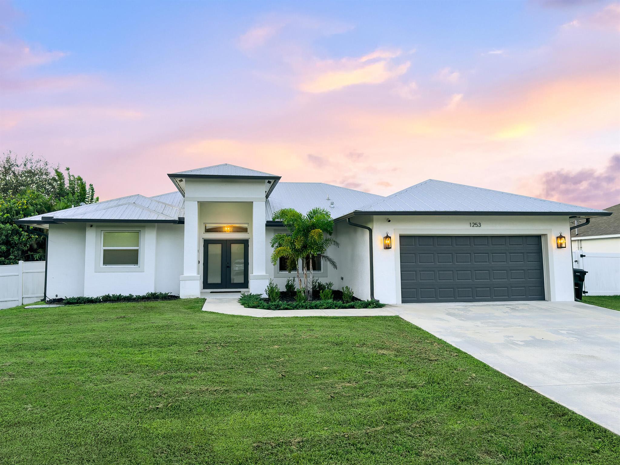 Come see this 2021 beautifully upgraded 3bd, 2bath + a versatile den, that offers luxury living with no HOA fees! A metal roof, impact doors/windows, large screened-in porch overlooking a fully fenced yard. A modern open-concept layout w/ luxury vinyl flooring throughout, a chef's kitchen w/ a large quartz island, custom vent hood, Cafe appliances, soft-close cabinets and many other functional features. An enlarged master suite with a tray ceiling, 2 walk-in closets, a spa-like bath w/ a freestanding tub and separate vanities. Samsung washer/dryer in the laundry + extra cabinet storage. Home also has security cameras, EV charger, smart appliances, thermostat, doorbell and much more. Prime location between the Turnpike and I95, close to the beach and Tradition's dining and shopping.