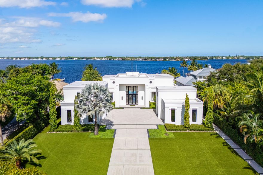 Experience the art of luxury living in this spectacular modern estate on the scenic Loxahatchee River in Jupiter, Florida. Tucked away on a private street, this custom-built masterpiece blends architectural sophistication, advanced technology, and the serene beauty of South Florida waterfront living.

Beyond the stately gates, the resort-style setting offers 127' of waterfrontage, a covered outdoor kitchen with large island and seating area and a 20' x 40' pool with spa. The meticulously landscaped grounds feature artificial turf lawns ensuring a pristine look year-round.  The private dock, with boat lift and floating dock for smaller boats, provides direct boating access to the Intracoastal Waterway and the Atlantic Oceanâ€''perfect for those who treasure the coastal lifestyle. The heart of the home is a grand great room, designed for both comfort and sophistication, with soaring ceilings and panoramic river views. The chef's kitchen is a true showpiecefeaturing a large central island and Miele appliances.  Custom terrazzo flooring, solid wood doors, and bespoke wood cabinetry and moldings throughout the home showcase craftsmanship of the highest caliber.  This residence offers six bedrooms, six full baths and four half baths.  The bedrooms include a primary suite with a spa-like bathroom, four en suite guest bedrooms for luxurious privacy and a guest suite featuring its own sitting room and kitchenette providing additional flexibility for guests or staff. Laundry rooms on each level add convenience for large-scale living. 

Designed for the ultimate entertainer, the home's amenities include formal and casual dining areas, a 1,500-bottle temperature-controlled wine cellar and wet bar, all overlooking the tranquil riverfront.

Every element of this home reflects thoughtful design and superior engineering. The Crestron home automation system provides effortless control of lighting, climate, and security, complemented by a Sonos sound system with 24 invisible speakers. Comfort and efficiency are ensured by four tankless water heaters, six zoned air-conditioning units, and a comprehensive camera and security system. The air-conditioned garages feature poured concrete flooring and a dedicated second-level storage area, offering both functionality and durability. Built with a concrete and steel structural system, the design pressures of this home can withstand winds exceeding 200 MPH, this residence is truly built to last.

This exceptional Jupiter estate embodies the pinnacle of South Florida living-a boater's and golfer's paradise where privacy, elegance, and waterfront tranquility converge.

Private. Polished. Perfectly Jupiter.