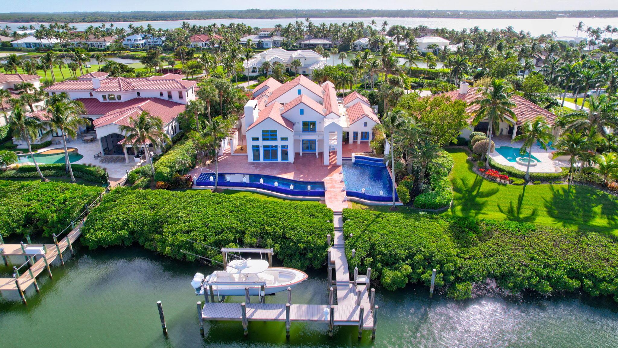 At the intersection of architecture, nature, and water lies this unparalleled estate in the exclusive community of Sailfish Point. Every detail has been meticulously crafted from the dramatic architecture to the resort-style mosaic pool spanning the width of the property. Plenty of natural light flows throughout the home with walls of glass and internal courtyards designed to offer private spaces. The chef's style kitchen has Thermador appliances, 2 islands, a breakfast area, and connects to the dining room via a butler's pantry. The expansive great room opens to the bar/lounge area perfect for entertaining. The primary suite offers a spa-like bath with steam shower and soaking tub. A protected dock, with a 24,000# lift, provides immediate access to the Indian River and Atlantic Ocean.