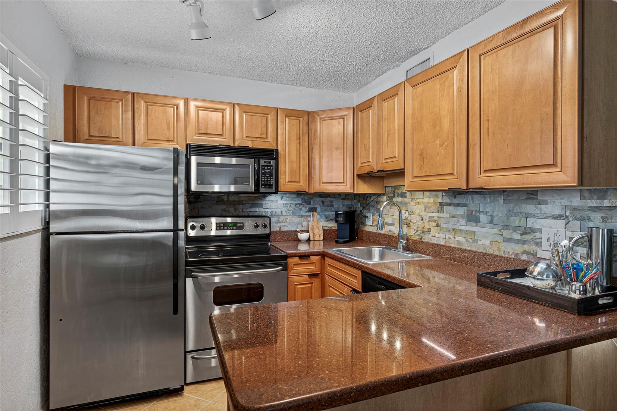 Discover the perfect blend of comfort & convenience in this charming Ground-Floor condo in the Gated & Highly Desired Community of The Grove at Wilton Manors. Only two blocks from vibrant Wilton Drive & just minutes from the Beach & Las Olas, this residence offers an Ideal Location. Bright & Airy featuring Plantation Shutters & Impact Windows, ensuring both style & safety. Open Kitchen with Granite Countertops & Stainless Steel Appliances. Unique to ground floor units, is a quaint Patio area perfect for relaxation. Residents of The Grove enjoy access to a Heated Swimming Pool, BBQ and a Clubhouse equipped w/meeting & kitchen facilities. New Roof, Ample Parking & Lovely Tropical Landscaping. It is also Pet-Friendly and boasts Low monthly dues, making it an attractive option for homeowners!