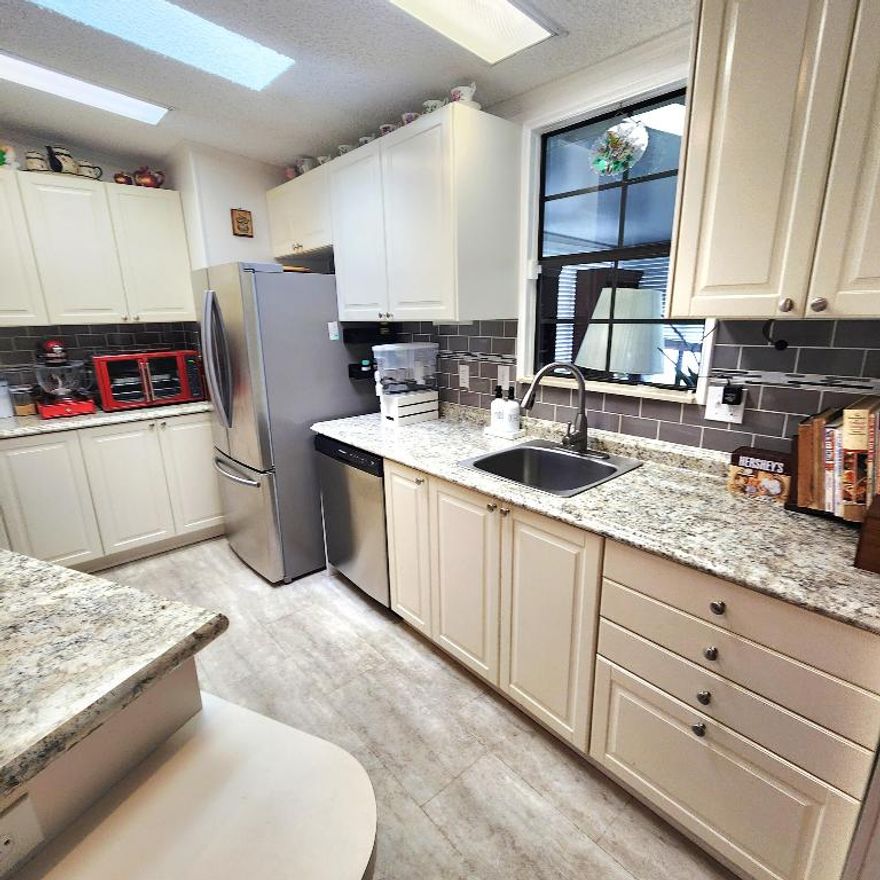 Sophisticated 2BR/2BA PLUS a DEN doubling as a 3rd bedroom or home office. Large green area is perfect for gardening, griling & pets! Home offers abundant light & boasts stunning vaulted ceilings. Walk in to bright bay windows dripping in natural light, etched glass, & an elegant WOOD-BURNING FIREPLACE along w/ built-ins set w/ a mini fridge. The bright Florida Rm is enclosed w/ screened windows. There are multiple outdoor patios great for relaxing & entertaining & a large grassy area ideal for enjoying outdoor activities. Major upgrades: 2025 roof, new flooring, 2025 dishwasher, 2021 AC, and newer appliances. Alarm ready, Shed. Roman tub/spa, abundant cabinetry, and termite-tented 2022. Gated community with pool, clubs, and amenities. Minutes to beaches, marinas, dining, and shopping!