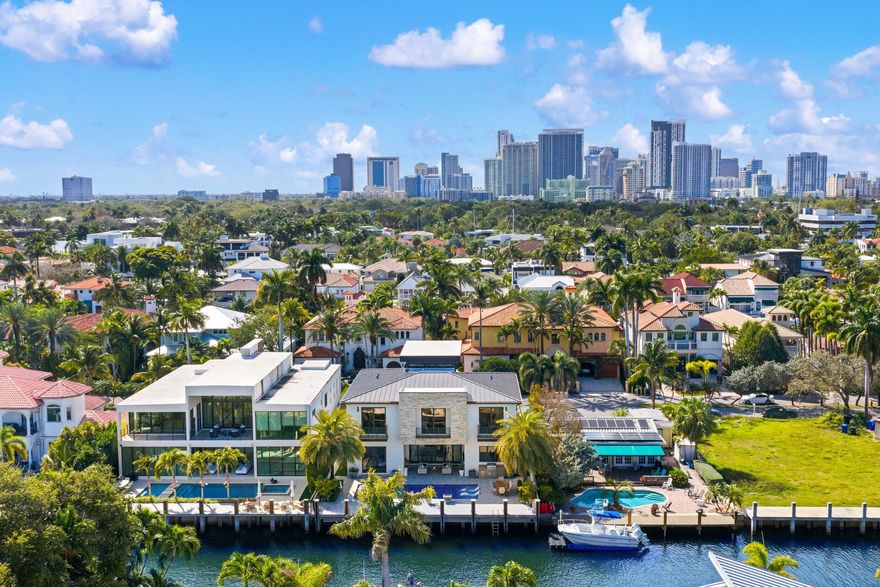 Located in Las Olas Isles, this modern residence by CES Design Group features a 7' elevation and a dramatic 32' double-height entryway that opens to interiors finished with porcelain floors, LED cove lighting, and an electric fireplace. The chef's kitchen is equipped with Sub-Zero & Wolf appliances. The layout includes a first-floor primary suite, club room with wet bar and cabana bath, and two laundry rooms. Accordion doors create seamless indoor outdoor living to a saltwater pool, spa, summer kitchen, and fully gated grounds. Built on pilings with Control4 automation, full-house generator, elevator-ready design, and a two-car garage with impact glass doors and room for lifts. Offered fully furnished! Moments from Las Olas Boulevard, dining, shopping, and the beach.