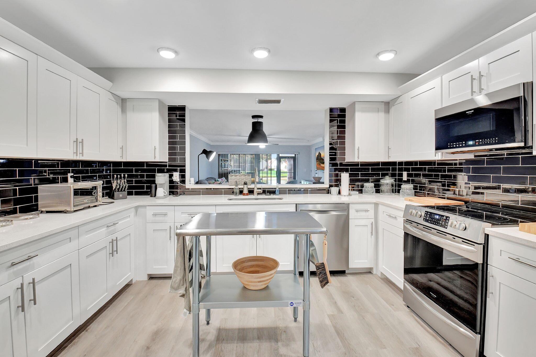 Stunning and completely renovated first floor condo with tremendous kitchen,  bonus two walk in closets,High end appointments and both a screened covered patio and an outdoor patio!  Water views in front and back. Could add a closet to make 3 bedrooms or keep the oversized office. Low fee with a COA that includes almost everything! Grills allowed on outside space only first floor units have this!