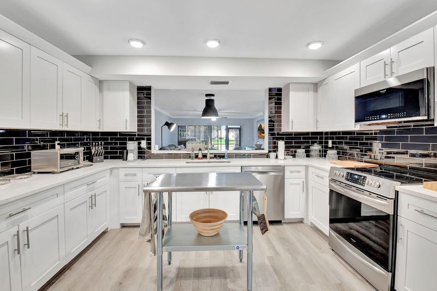 Stunning and completely renovated first floor condo with tremendous kitchen,  bonus two walk in closets,High end appointments and both a screened covered patio and an outdoor patio!  Water views in front and back. Could add a closet to make 3 bedrooms or keep the oversized office. Low fee with a COA that includes almost everything! Grills allowed on outside space only first floor units have this!