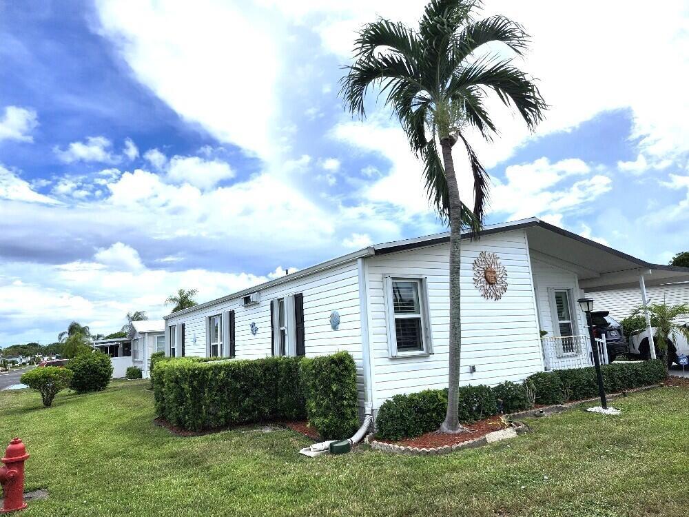 ON LARGE CORNER LOTThis beautiful home located Boynton Beach with its own sprinkler system. Tile floors, eat in kitchen, granite counter tops and stainless appliances. PLUS Accordion hurricane shutters++storage room.two bedroom/two bath The living room is large that can become a living dinning area. There is a enclosed lanai with a separate entrance in the side of the home. There is a double car parking, Double sink vanity in the large master bedroom.