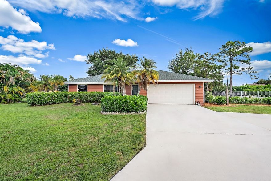 Discover the perfect blend of country serenity and modern comfort in this beautiful 3-bedroom, 2-bath Loxahatchee retreat. Set on over an acre of lush land, this charming residence offers a spacious, fully fenced yard, ideal for pets, horses, or future pool plans. Inside, timeless tile flooring flows through light-filled living spaces and a thoughtfully designed split floor plan. The primary suite features a spa-inspired bath with dual vanities and a glass-enclosed shower, while guest rooms share a full bath with a tub-shower combo. Enjoy evenings on the expansive screened porch overlooking your private grounds. With a two-stall barn, storage space, and no HOA, this home is a rare find just moments from Seminole Pratt and all local conveniences.